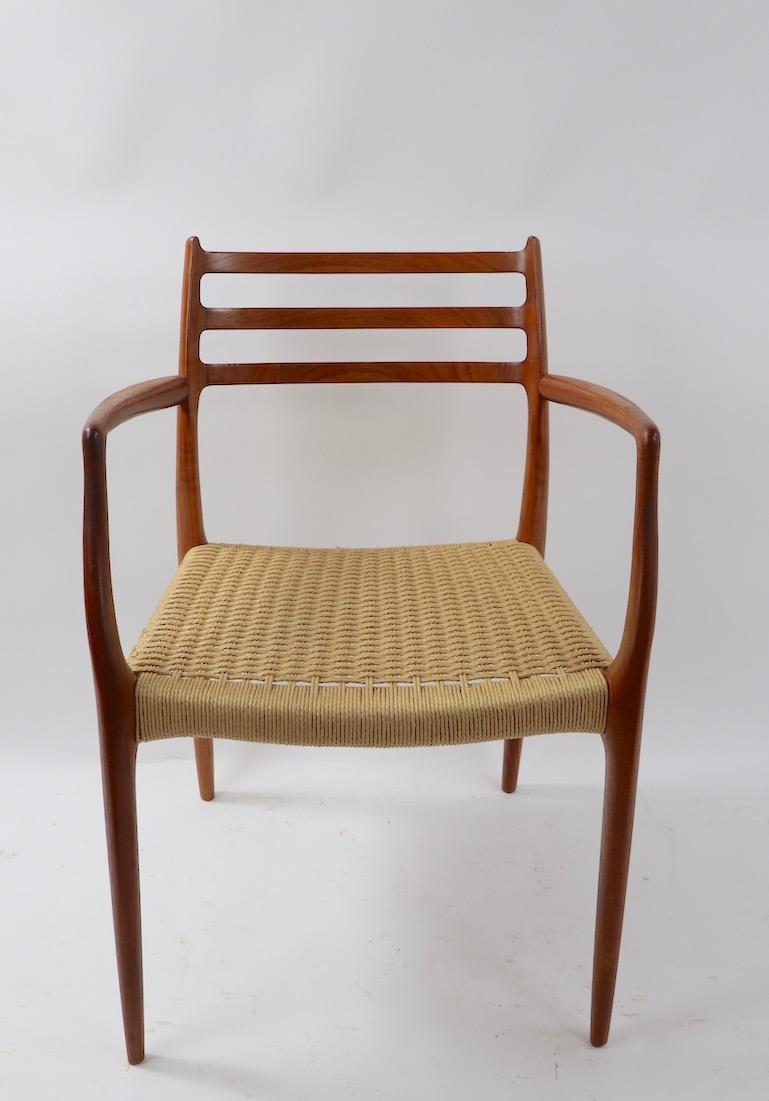 Wonderful set of 8 Danish modern dining chairs by Neils O. Moller for Jl. Moller. This set consists of 2 armchairs ( model 62 ) and 6 armless chairs ( Model 78 ). Constructed of solid teak, with papercord seats, this set is in original condition,