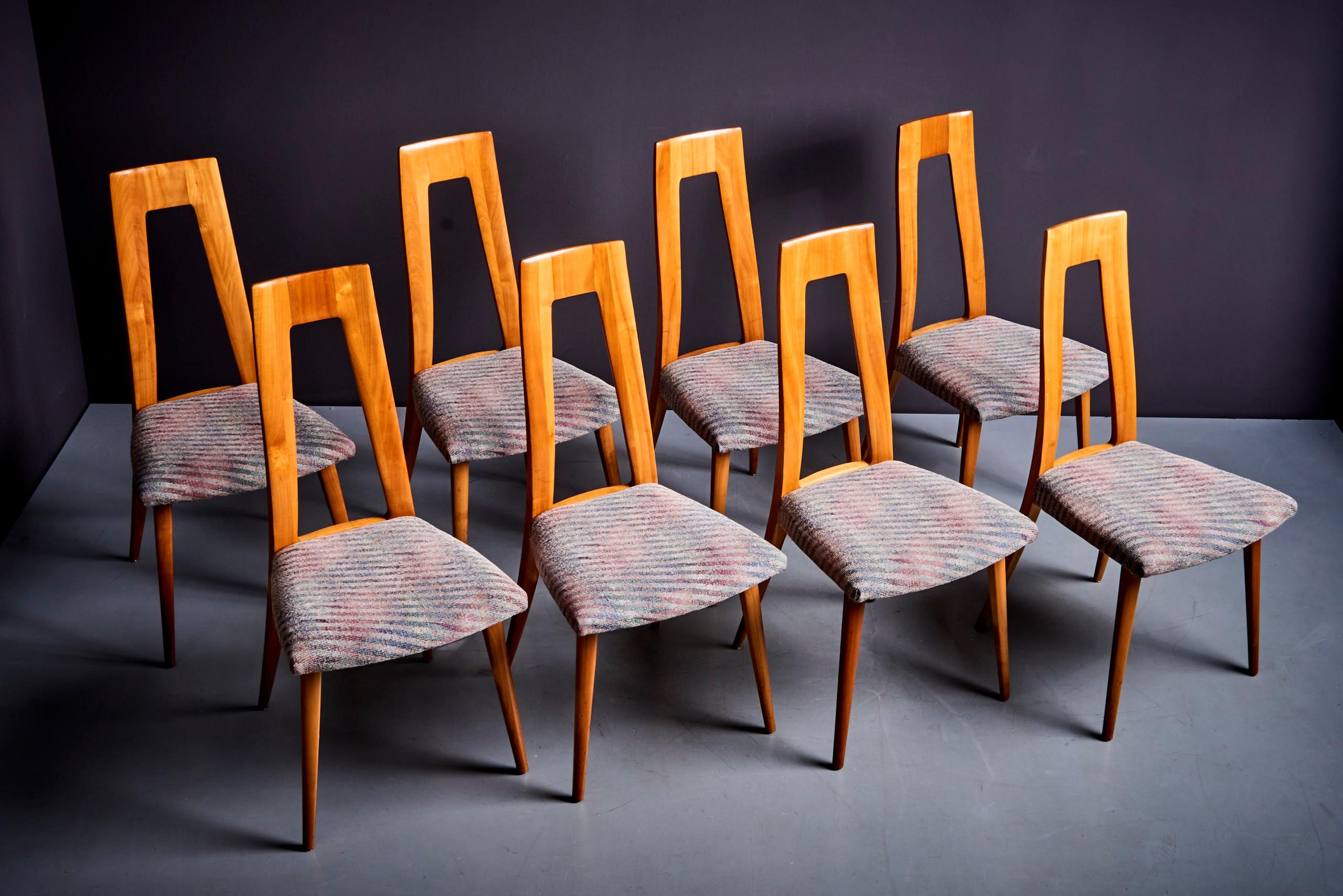 Ces chaises sont fabriquées en bois de cerisier et présentent un design épuré et contemporain. Les dos sont hauts et anguleux, avec un centre ouvert distinctif, ce qui leur confère un aspect moderne et architectural. Les cadres en cerisier ont une