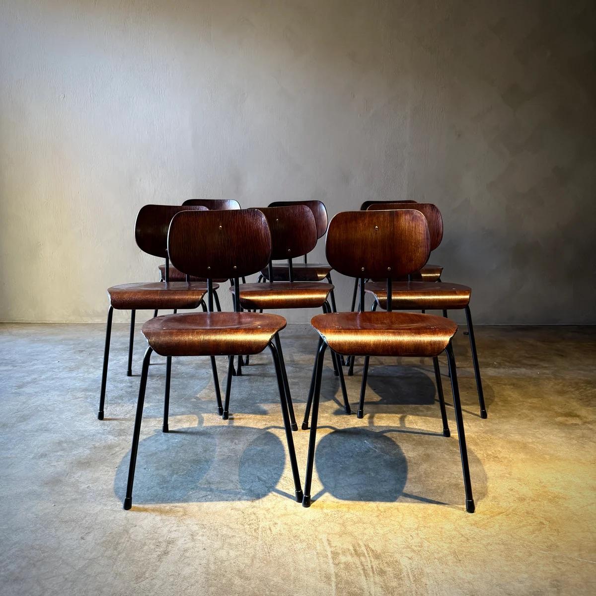 Questo set di otto sedie da pranzo italiane della metà del secolo scorso presenta una silhouette minimalista con strutture in metallo nero e sedute in legno di noce, incarnando uno stile elegante e industriale. Il loro design senza pretese e le
