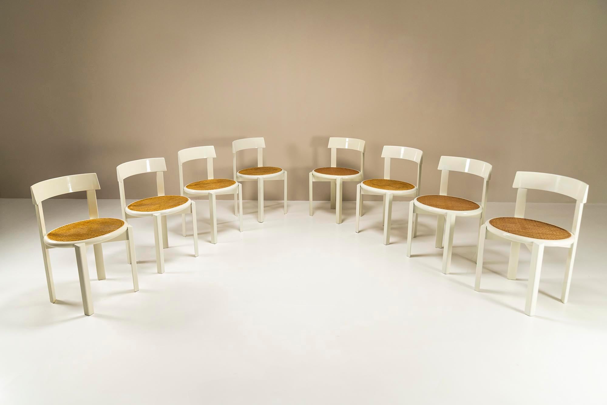 Set of 8 dining chairs in white lacquered wood and wicker. This set of eight chairs is a real pleasure to look at and their design gives an airiness to any interior. They were produced in the Italy of the 1970s and where at first glance they appear