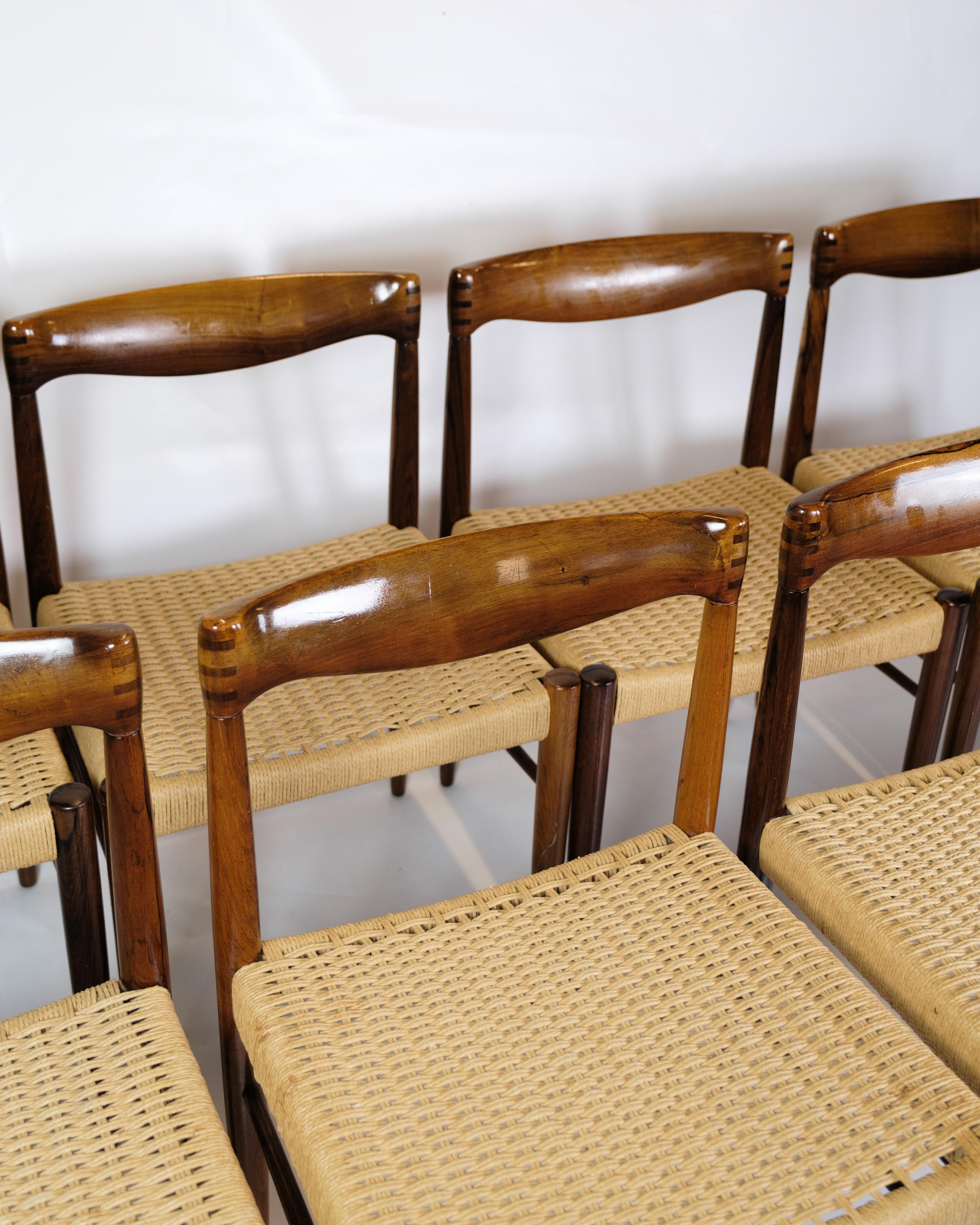 This set of eight dining table chairs is a splendid example of Danish furniture art from the 1960s, designed by Henry W. Klein and produced by Bramin. The chairs are made of rosewood and adorned with flat wicker seats, giving them a distinctive look