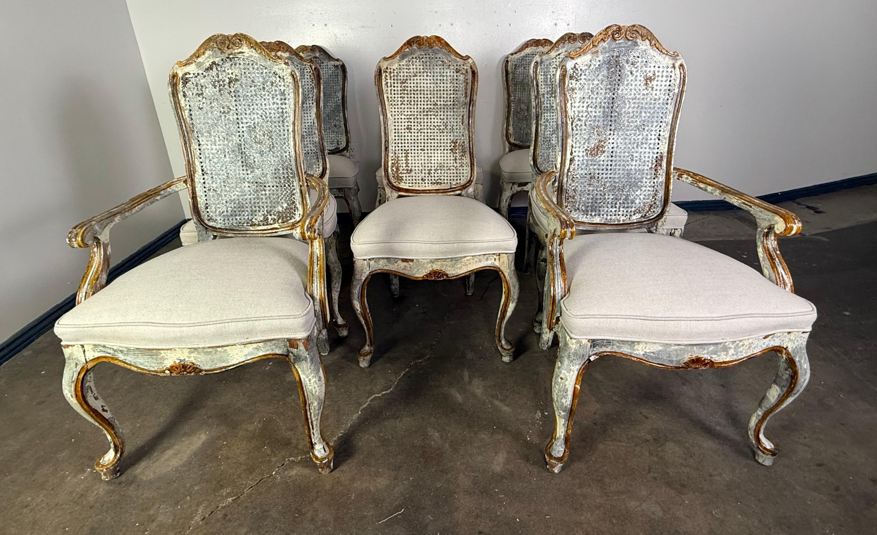 This elegant set of eight French Louis XV style dining chairs exudes timeless charm and sophistication. The carved frames feature graceful cabriole legs and subtle cresting along the backs, showcasing the refined craftsmanship of classic French