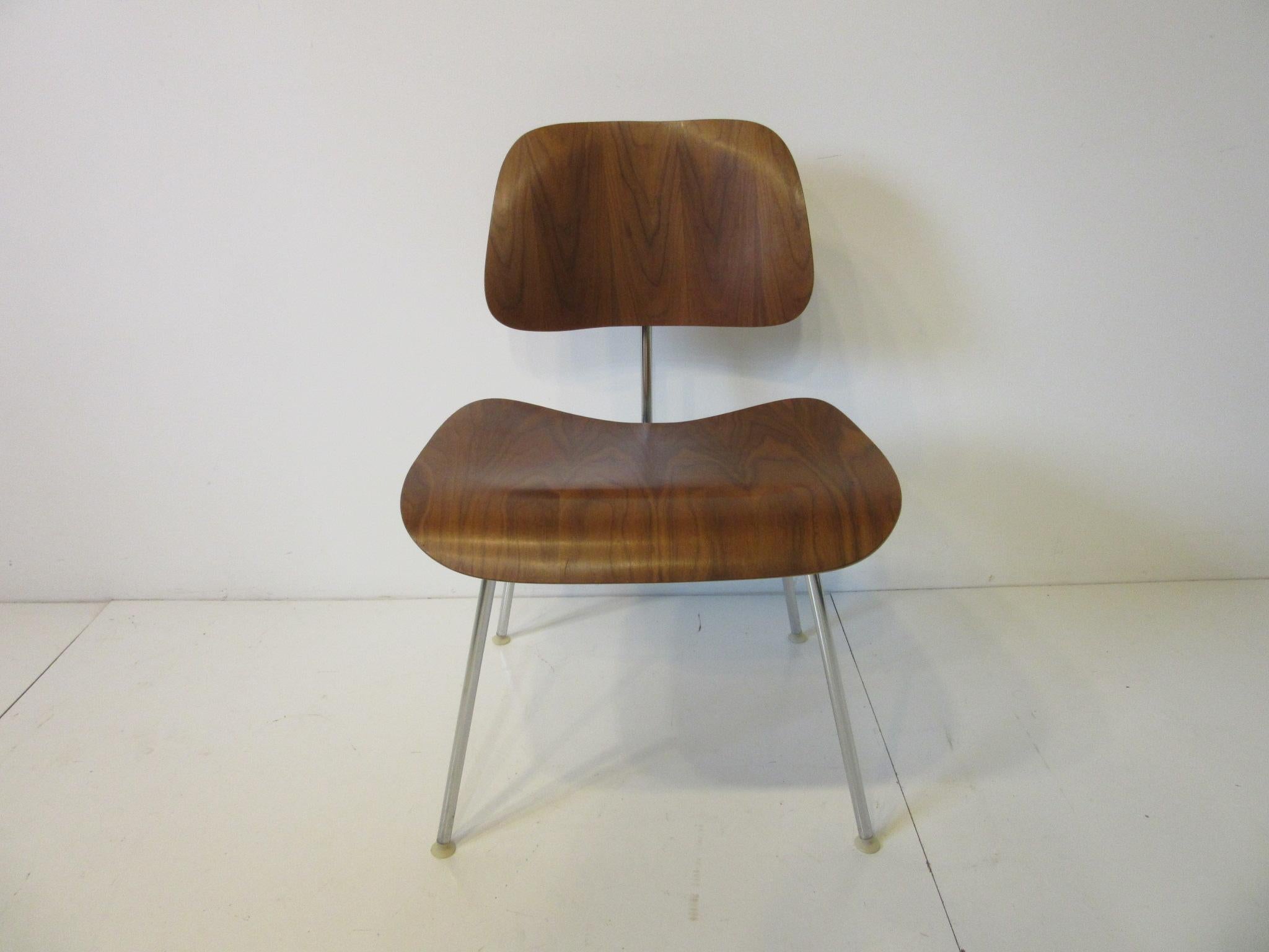 A set of eight well grained walnut DCM dining chairs with chromed metal frames and nylon foot pads, retaining the original manufactures labels by the Herman Miller Furniture company. These have a great patina all from the same original owners estate.