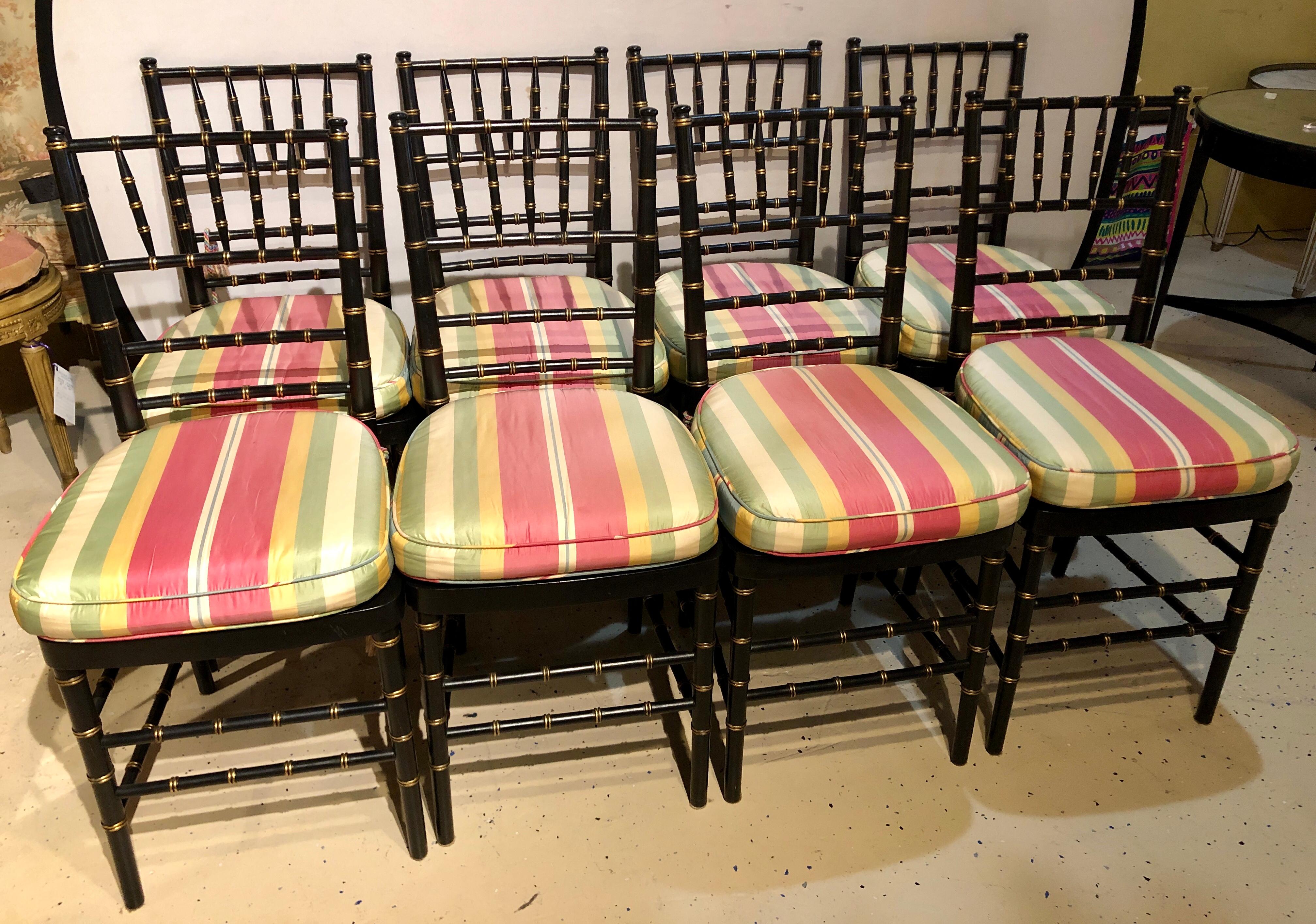 Set of 8 ebony and gilt bamboo style side chairs. Strong and study with stripped upholstered cushions.