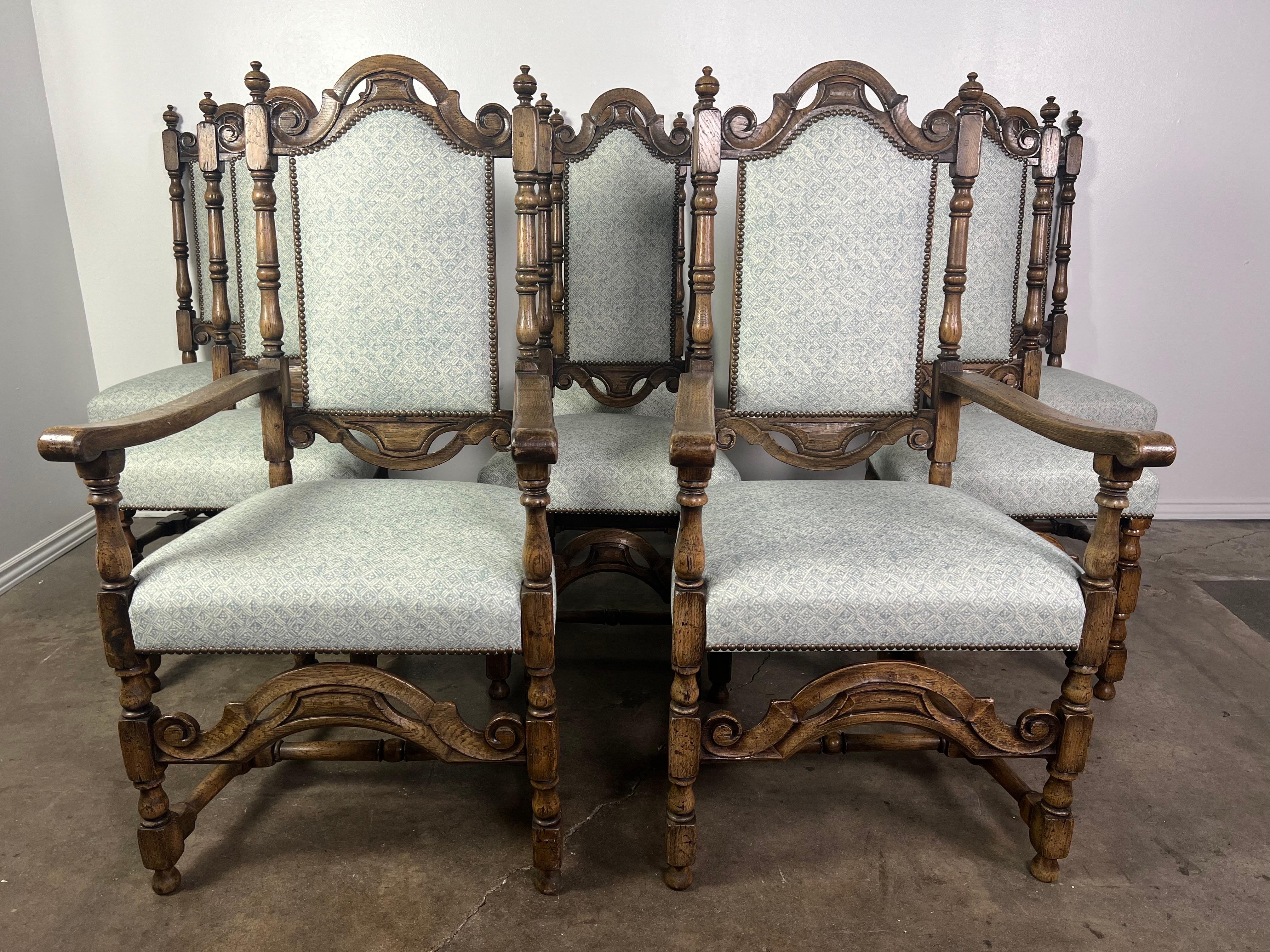 Set of eight 19th century Jacobean style English dining chairs with Jacobean carving and turned elements throughout. These recangular shaped set has been newly upholstered in a modern fresh printed bluish gray & cream printed linen with nailhead