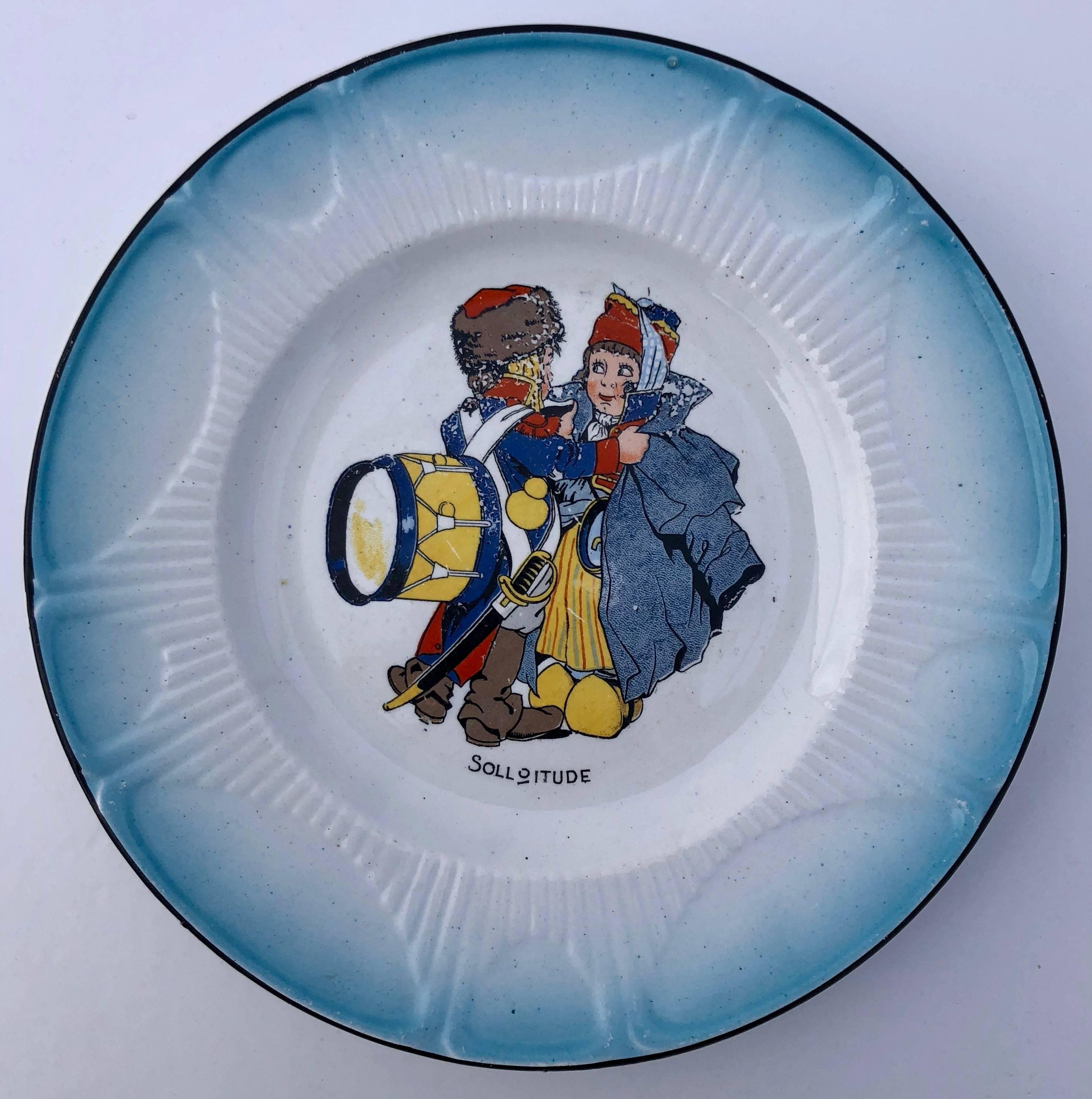 This is a lovely set of colorful French faïence transferware white plates with scenes of children dressed up in various Napoleon army costumes. Each plate has a charming French phrase which captures the sentiment of the scene and a French blue trim