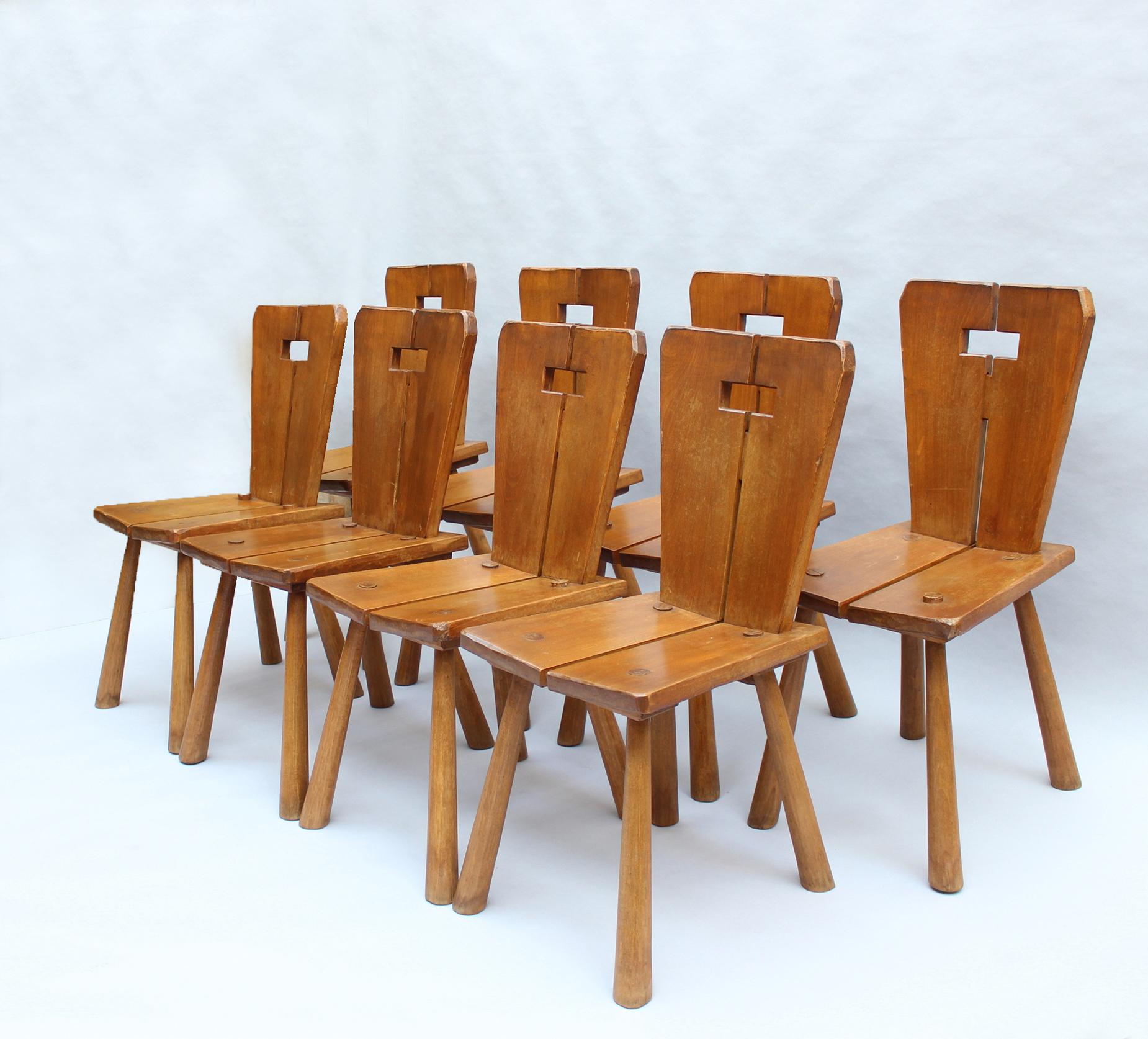 Ein Satz von acht feinen französischen Beistellstühlen aus massiver Buche der Jahrhundertmitte mit einem kreuzförmig ausgeschnittenen Griff in der Rückenlehne.
Die Mindestabnahme beträgt 4 Stühle.
     