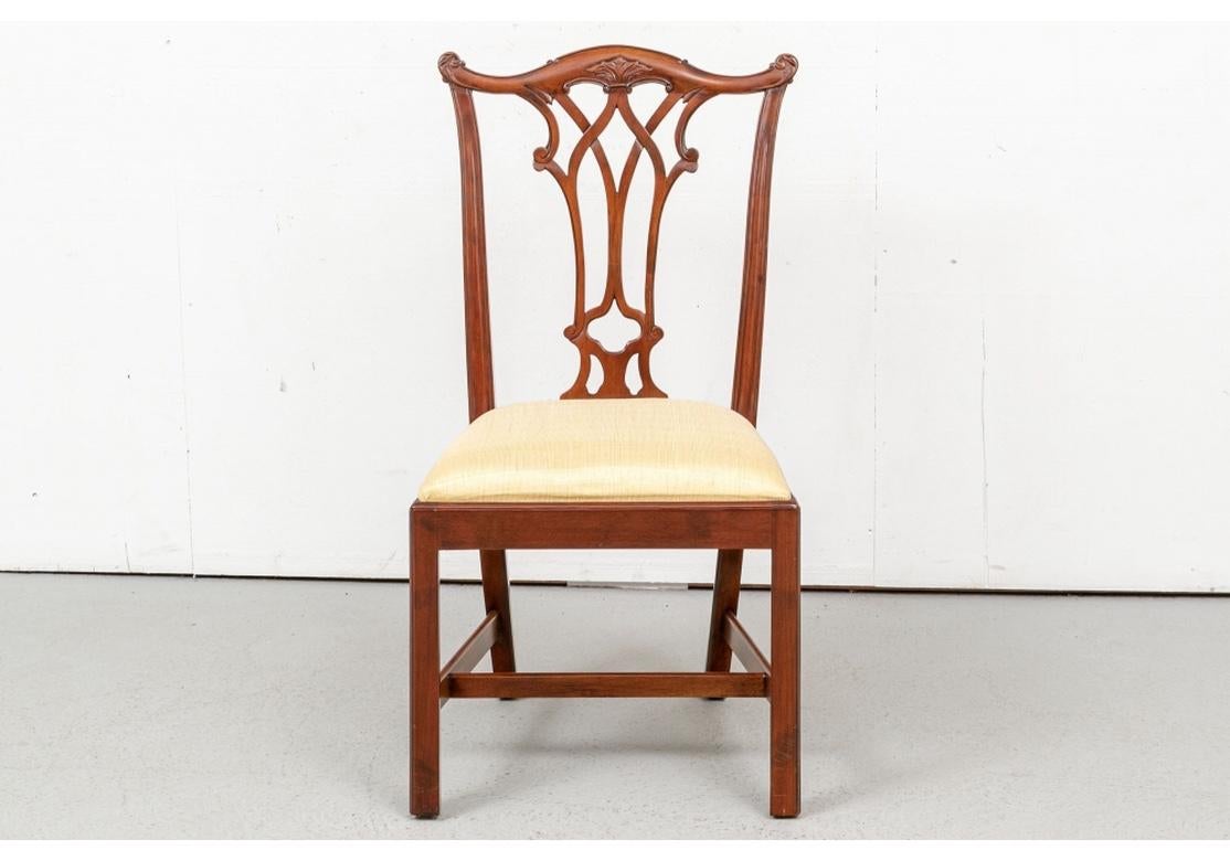 A fine quality set of dining/office chairs by Manor House Ltd. and having a medium stain and soft pleasing polish, the finish called, “Sun Faded” by the maker. Including two arm and six side chairs. With classic Chippendale backs with scrolled leafy