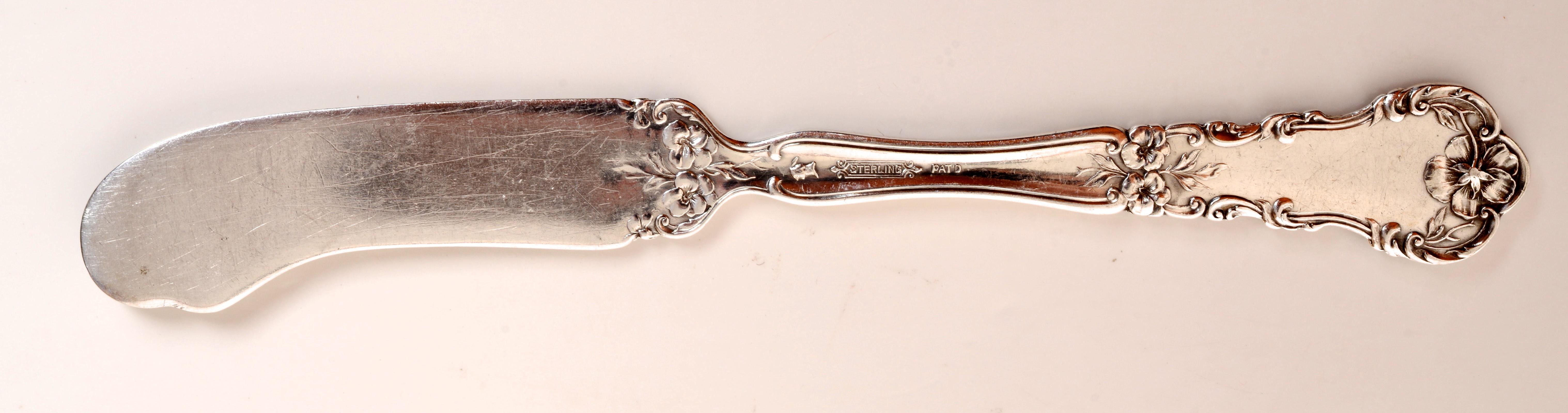 Set of 8 Flat Handled Butter Knife Meriden/International Silver Pansy Pattern. With a crisp floral decoration representative of the Art Nouveau movement and they are in good vintage condition with a beautiful patina.