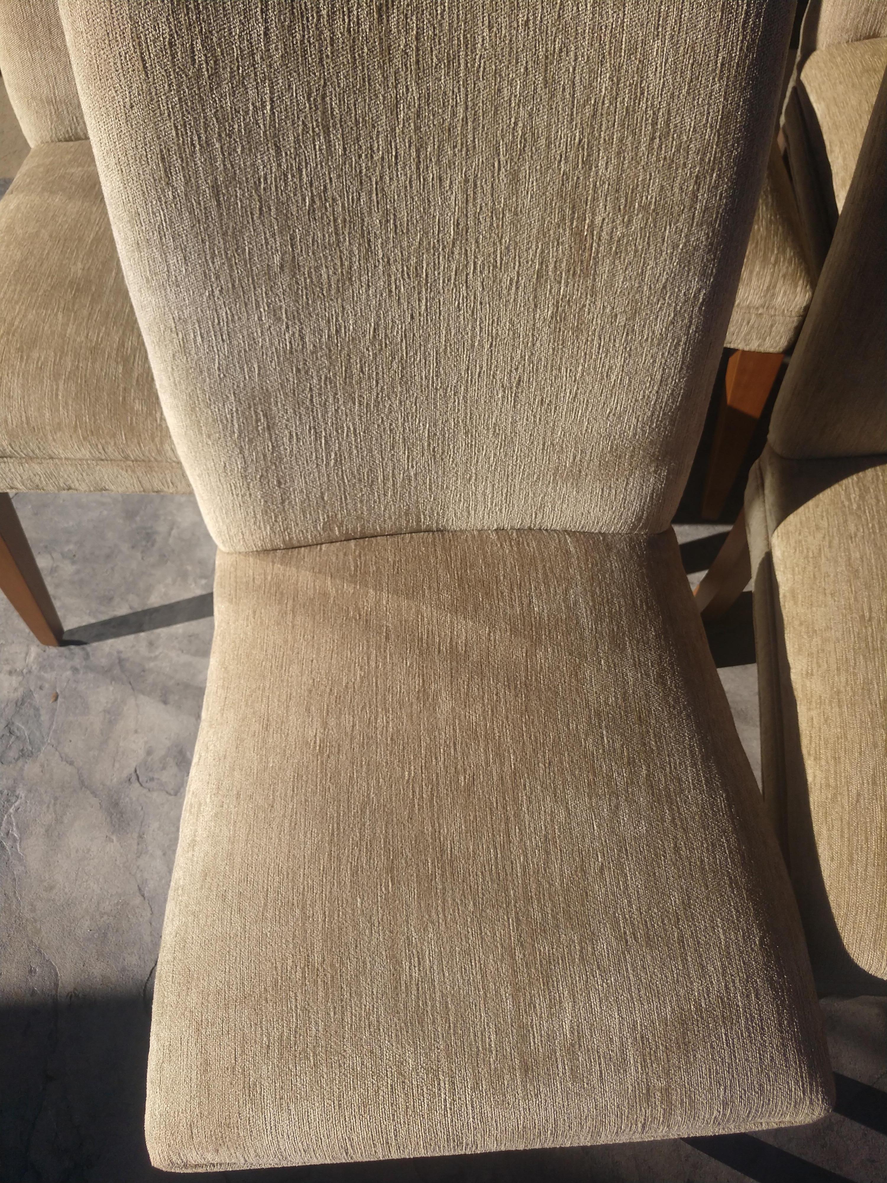 Set of 8 Upolstered dining chairs by Mitchell Gold for Restoration Hardware. Seat & back covered in a gold beige satin blend. Hardwood legs. Chairs are in excellent vintage condition with minimal wear. One tiny stain on a seat. Haven't tried to