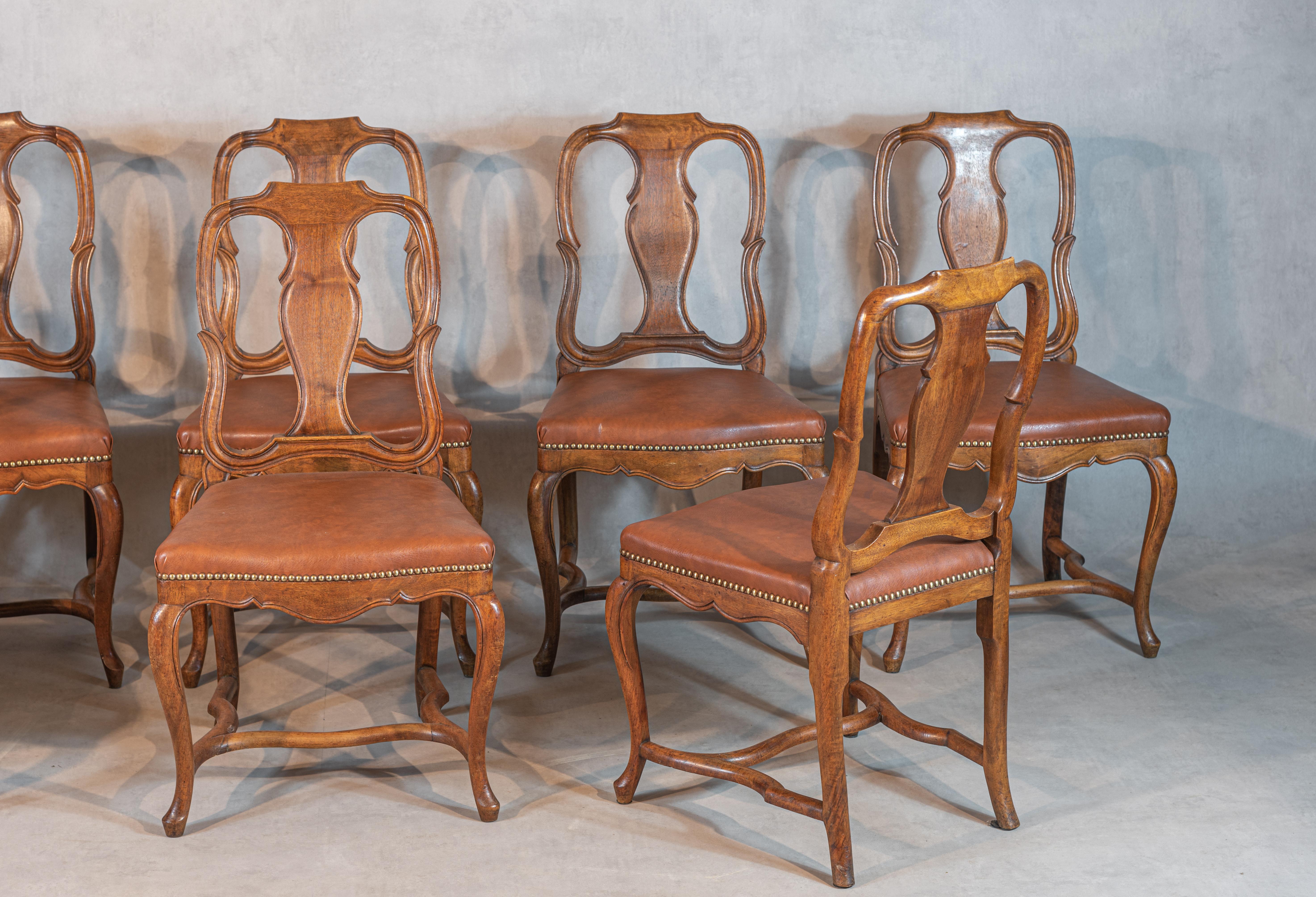 Refined and imposing, this set of eight French 19th-century Empire-style walnut chairs is a stunning example of traditional craftsmanship. The solid walnut construction of these chairs ensures both durability and beauty. The unique design and allure