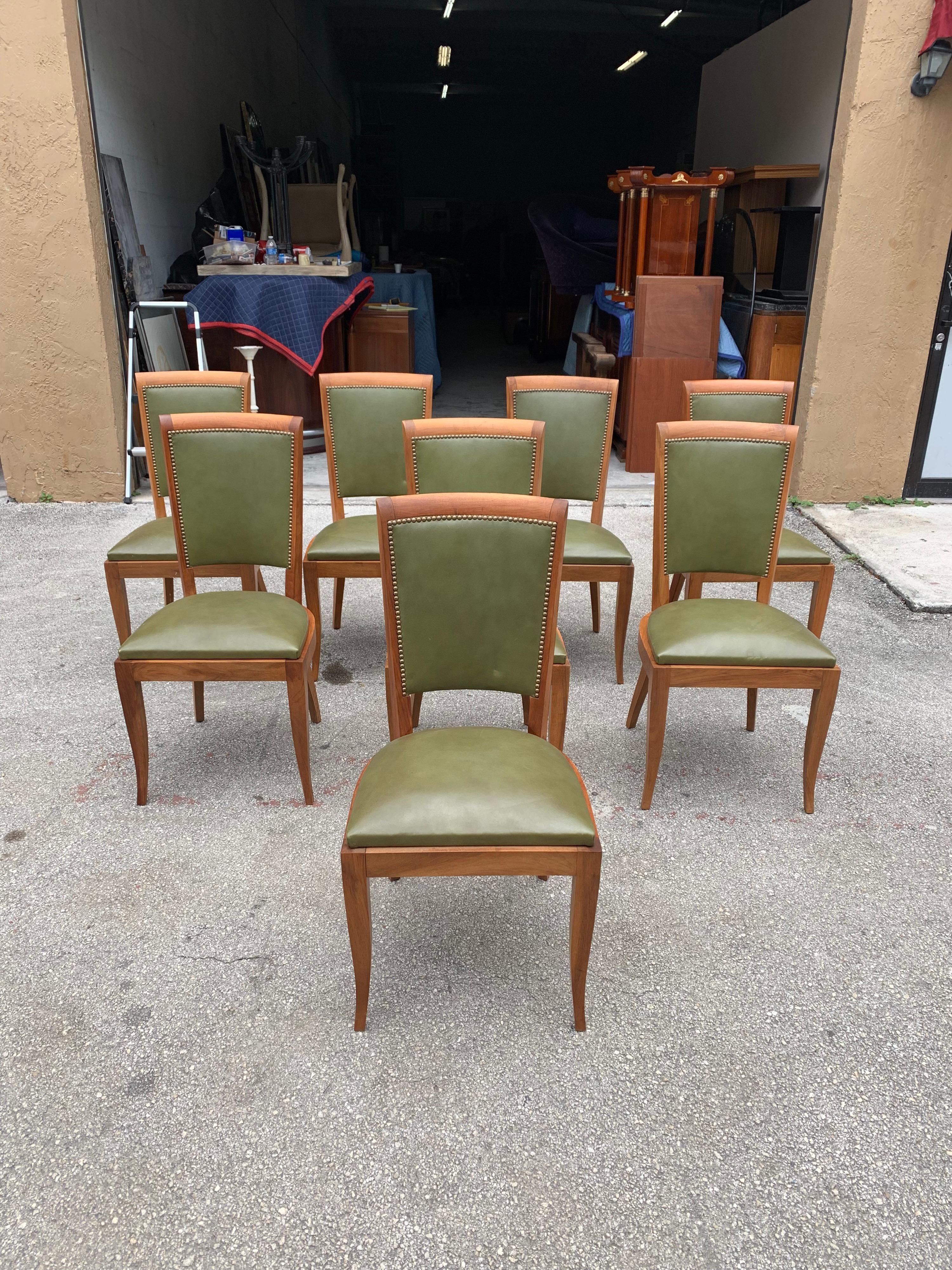 Classic set of 8 French Art Deco dining chairs solid mahogany, the chair frames are in excellent condition. The green leather color is original in very good condition. We travelled to buy all our pieces in France. We bought this beautiful set of 8