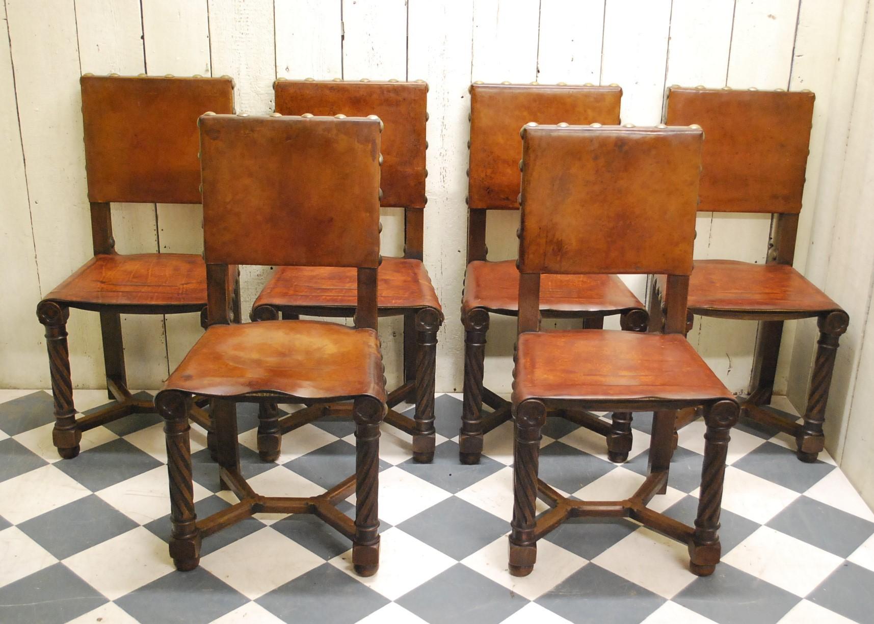 A good set of eight French gothic oak and leather dining chairs, circa 1900. Standing on fluted twist legs united by chamfered stretchers. At the tops of the legs are blind fretted quatrefoils, with thick leather seats supported by webbing. Both the