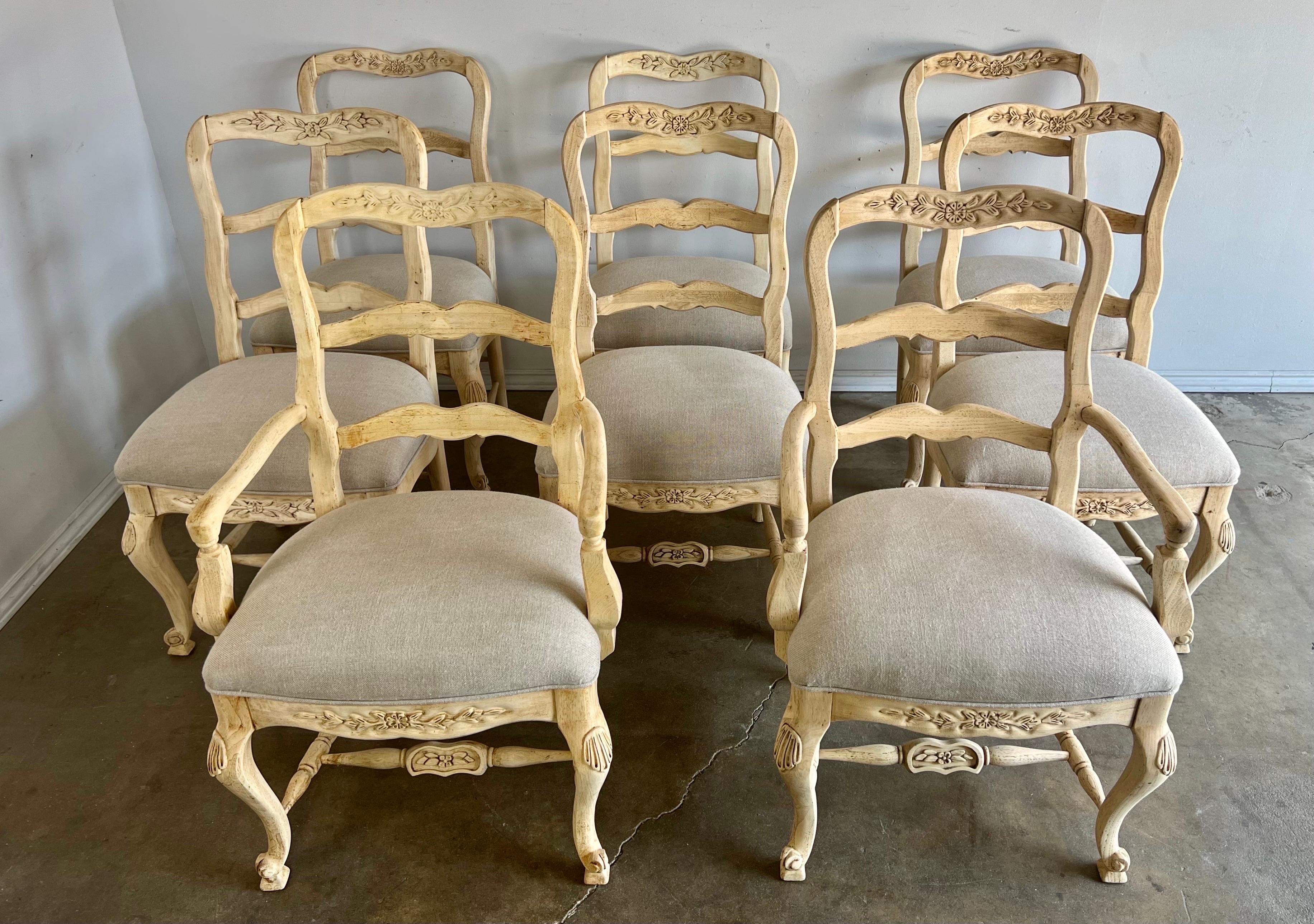 Set of Eight 1930's French Provincial style ladder back dining chairs. The chairs stand on four cabriole legs. The dining chairs have a natural wood finish and new Belgium linen upholstery.

Size side chairs-22