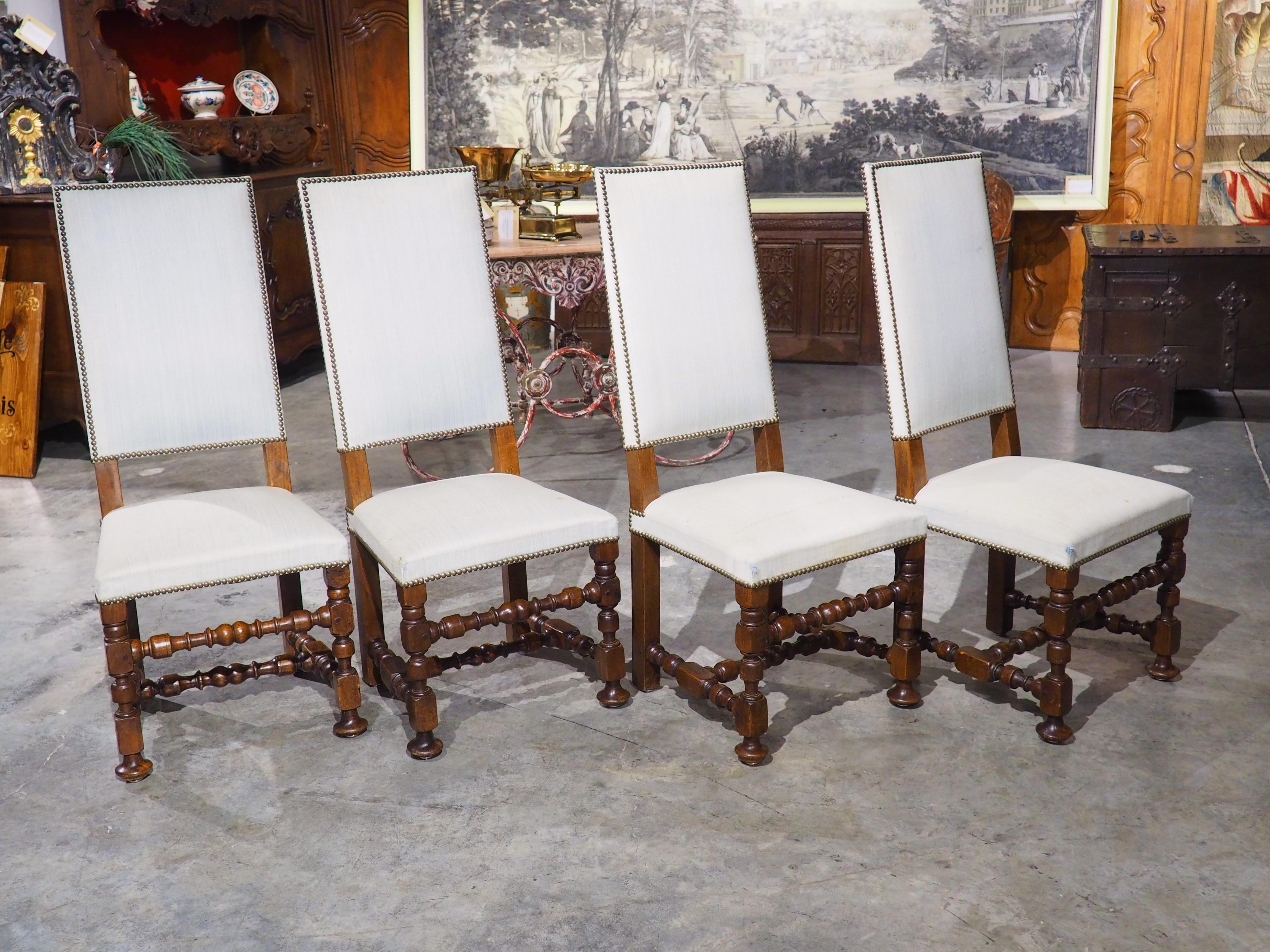 Produced in France, circa 1920, this set of eight oak dining chairs are in the style of Louis XIV. The straight backs and seats made from simple sets of turned and block carved wood make for a style that is still relevant and easy to work with in