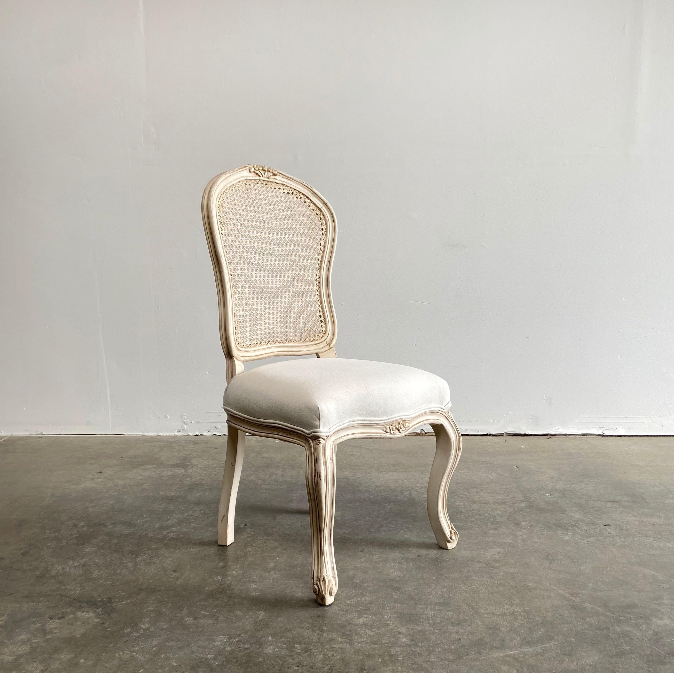 Set of 8 hand carved French Louis XV style painted and upholstered cane back chairs.
Distressed painted antique cream colored cane back dining chairs, with cotton upholstered seat.
Measures: 21” W x 22” D x 42” H
Seat height 20”
Seat depth