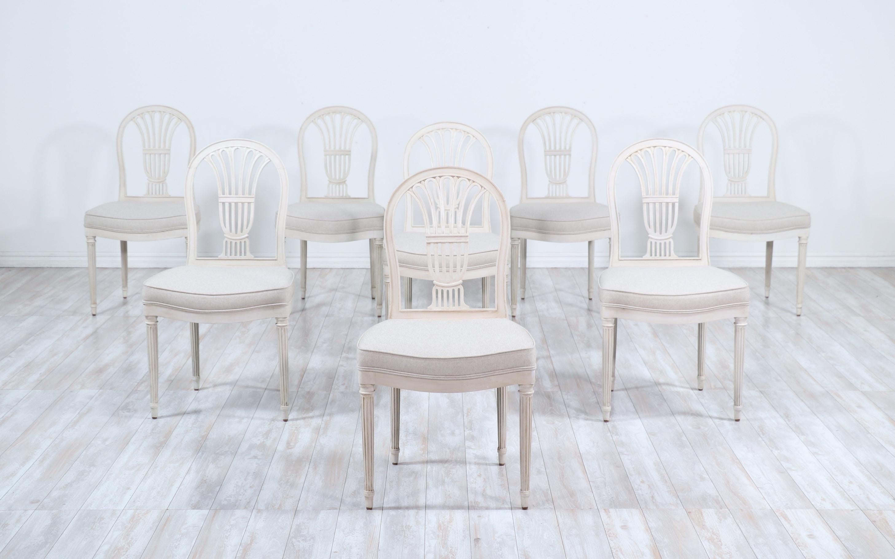 Gorgeous, French 1920s set of 8 dining chairs in the Louis XVI style. 

 The chairs feature beautifully carved details, a cream/ greige paint finish and new cotton linen canvas upholstery. 

 The chairs are sturdy and ready for many more years