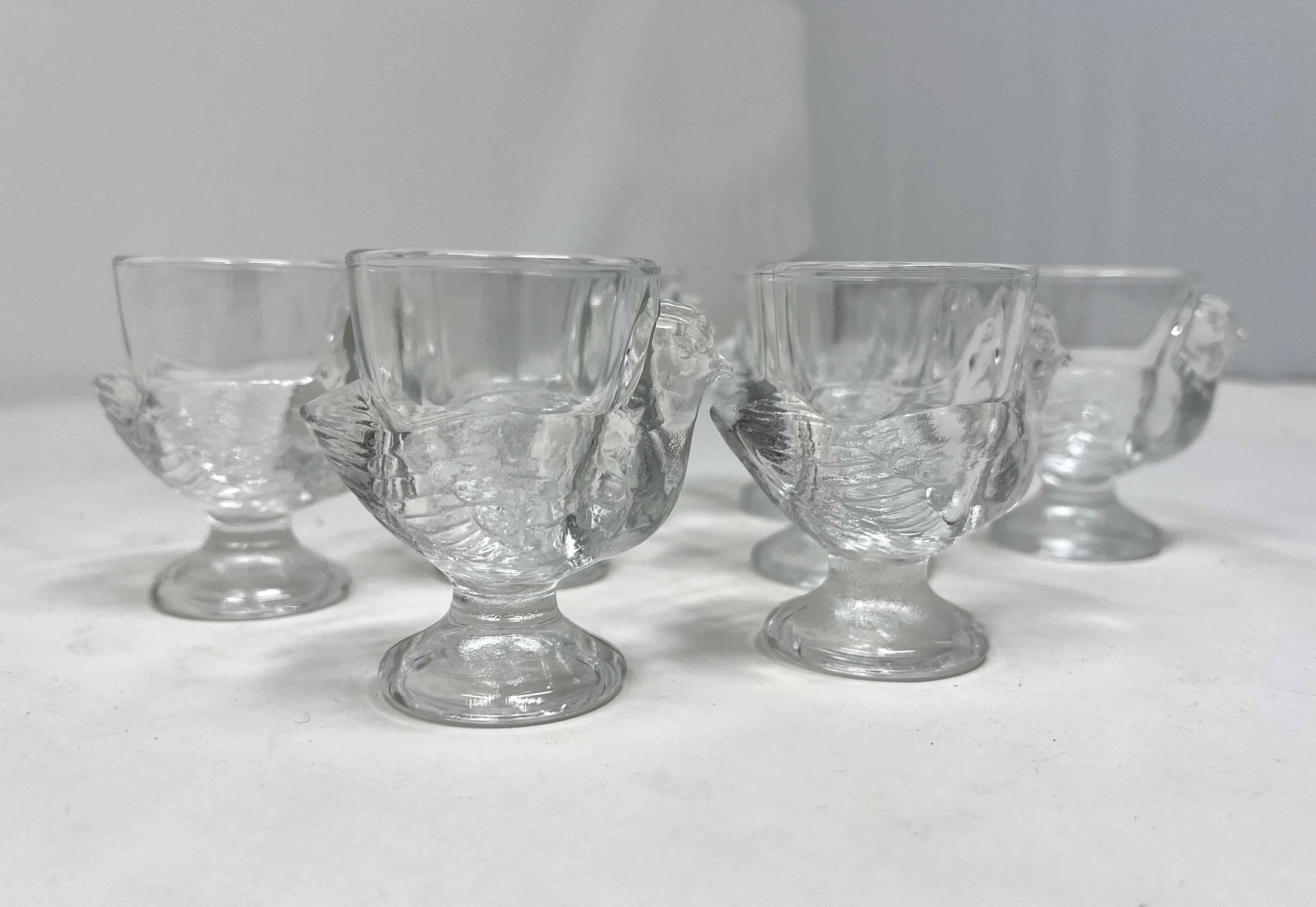 Set of 8 clear pressed glass egg cups made in France by Luminarc -- detailed as chicken hens! Nice large set to serve poached eggs for a big gathering. Also great for all kinds of small storage.

Very good to excellent vintage condition. No breaks