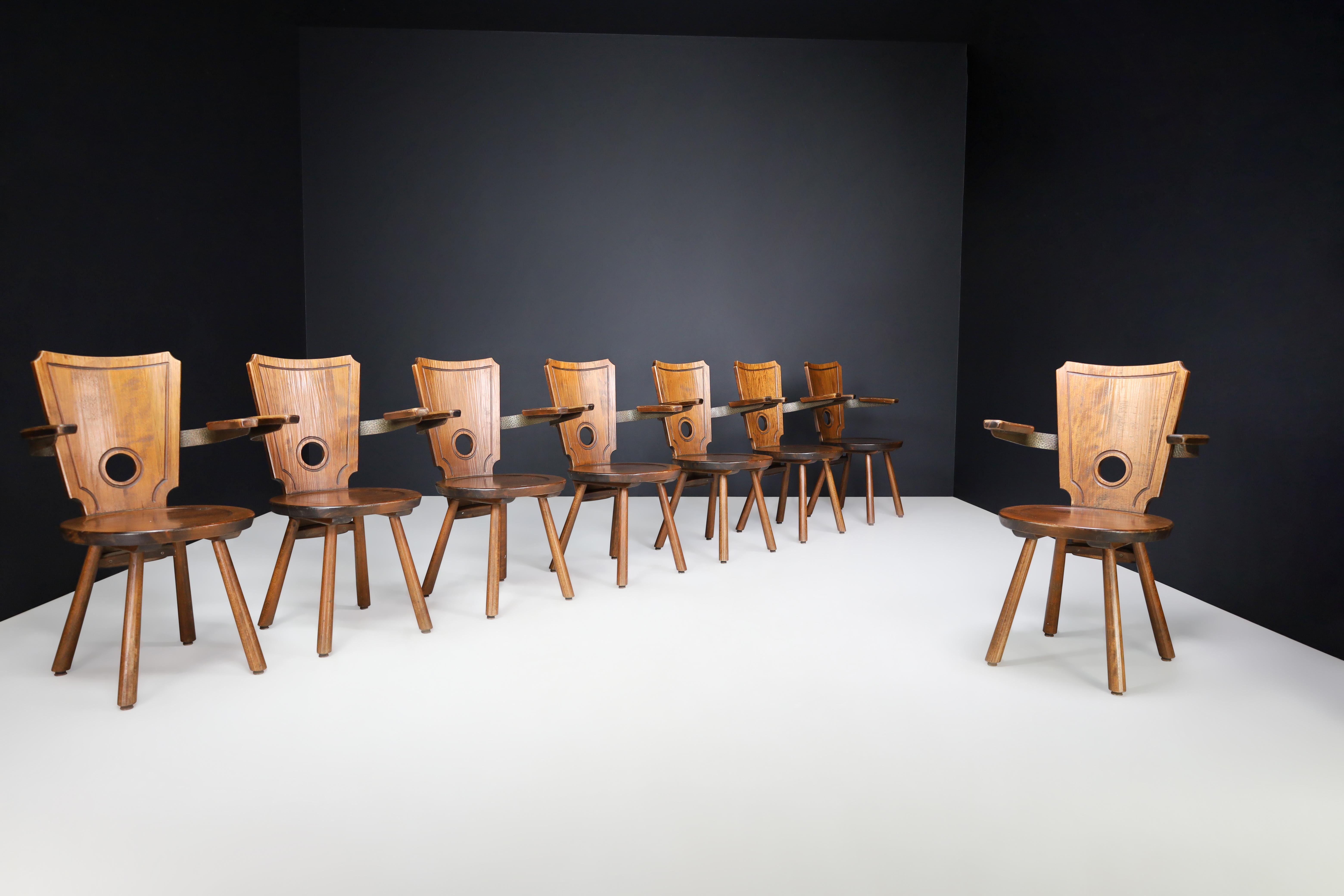 Set of 8 French Modernist Dining Chairs in Stained Oak and Brass, 1960s

This exceptional set of eight French dining chairs from the 1960s captures the essence of mid-century modernism with a raw, architectural edge. Crafted entirely from stained