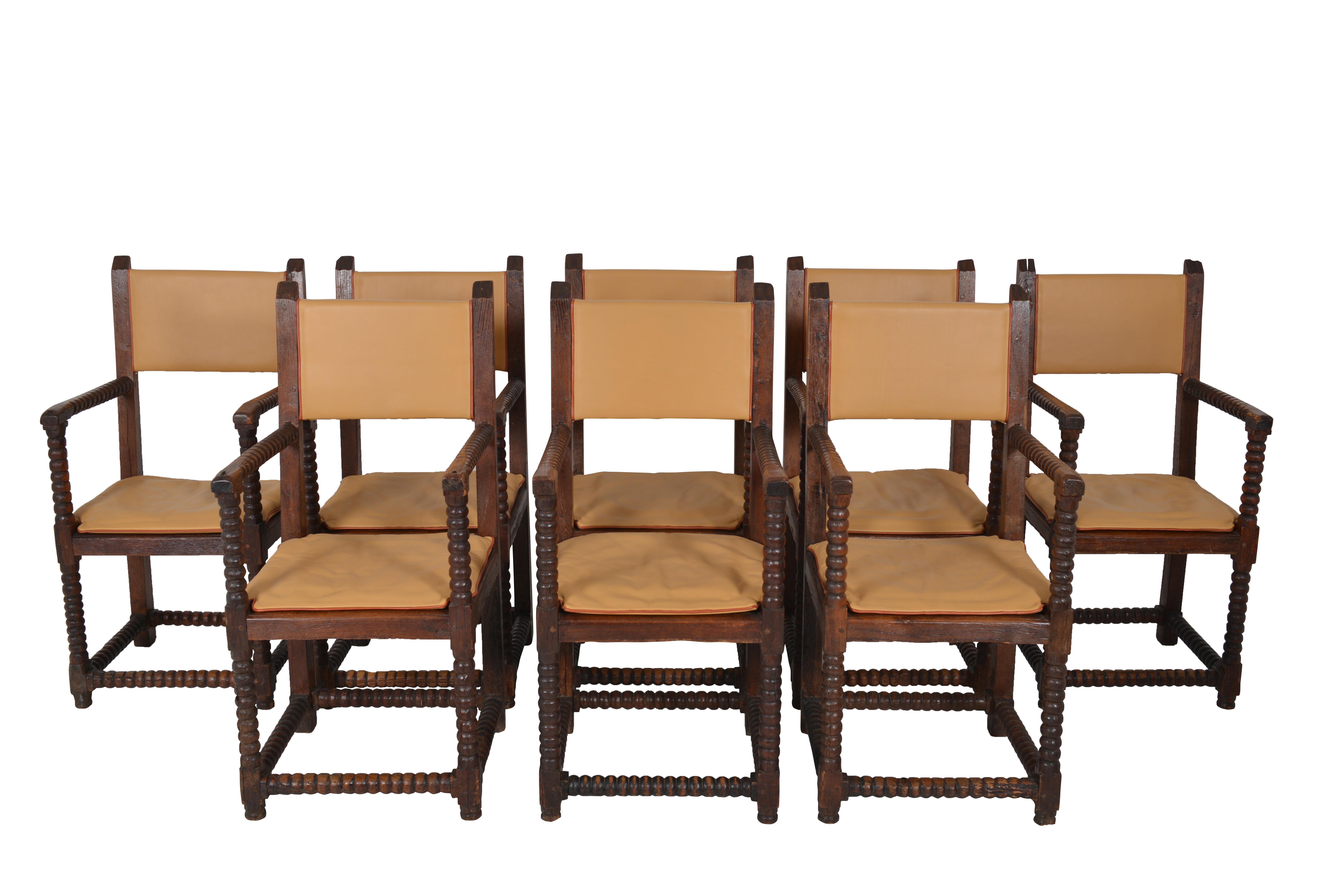Amazing set of 8 oak French Louis XIII dining chairs. These “spool” armchairs have bobbin turned legs and armrests. “Spool” is a classic design since the 1600. The arms, legs and rails were carved on a lathe to create equally ball shapes. The chairs
