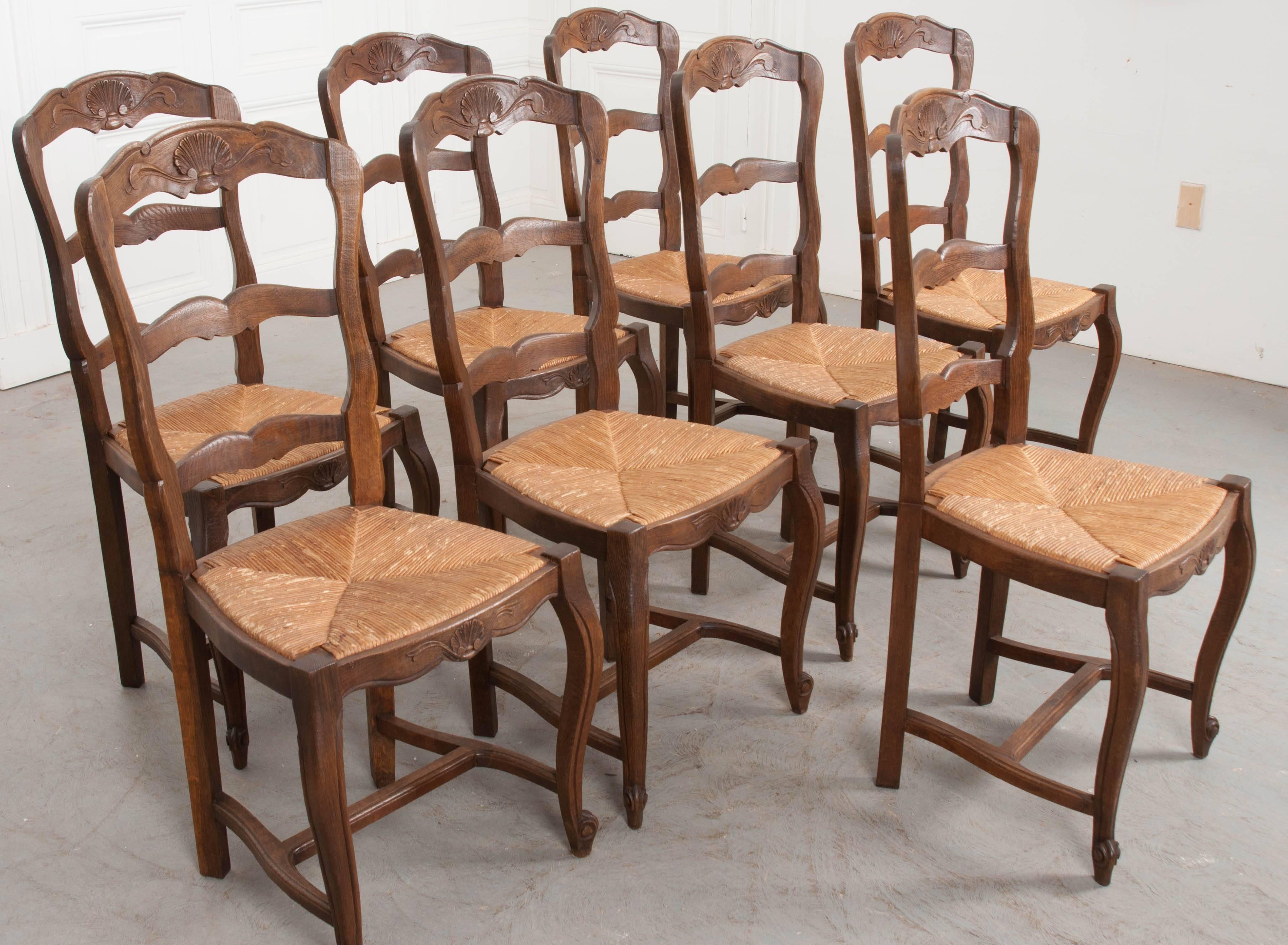 20th Century Set of Eight French Oak Ladder Back Chairs with Rush Seats