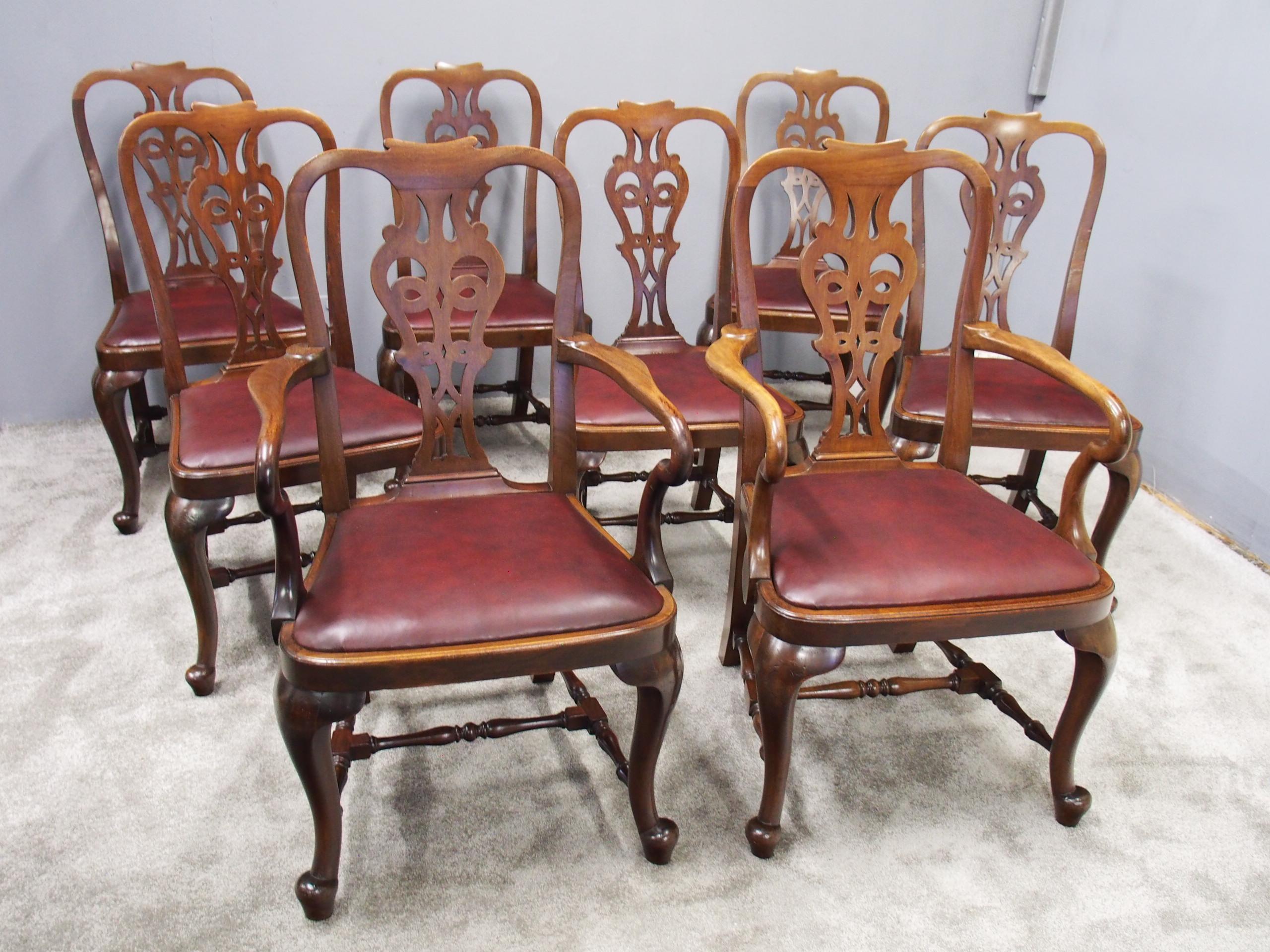 Set of 8 mahogany George II style armchairs. With shaped toprail, Queen Anne style splat and open fretwork leading to a recently re-upholstered leather drop-in seat pad. The arms finish in a shepherds crook to the front and are fixed to the side