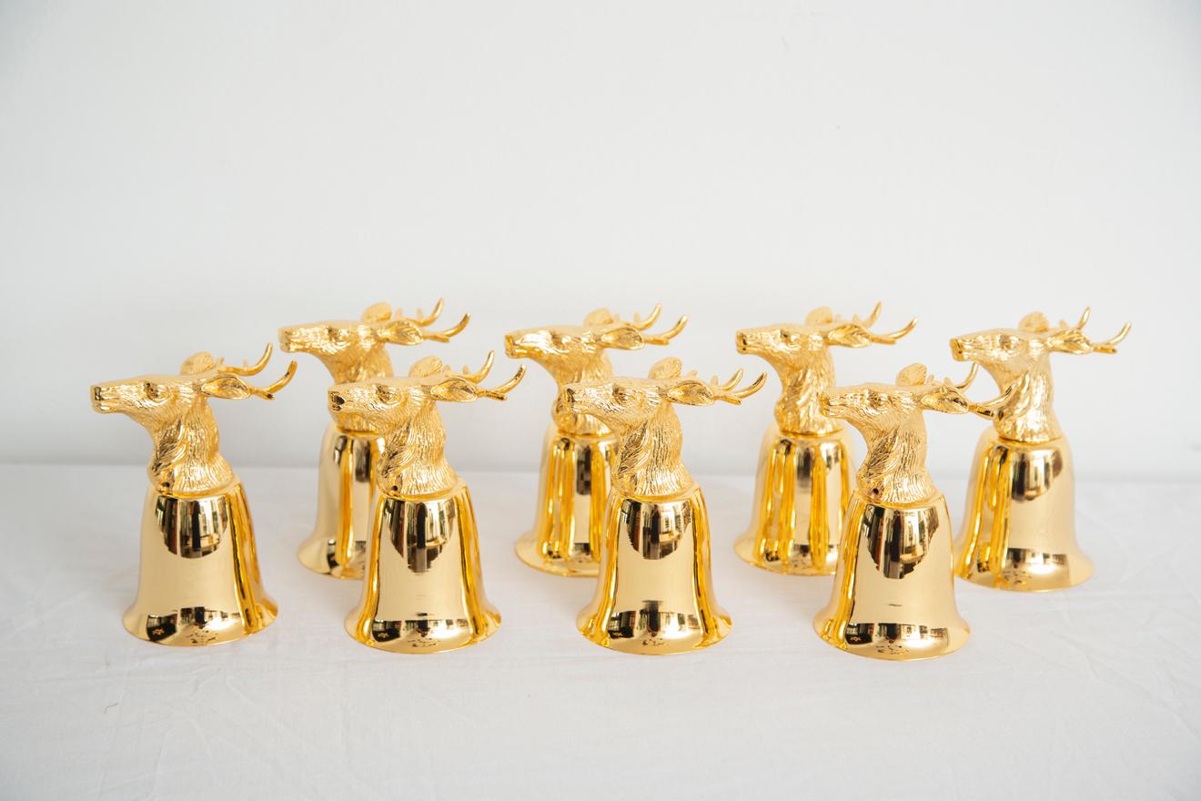 Newly gold plated set of 8 stirrup cups/goblets with deer, stags or elk's heads.