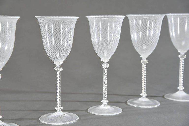 This is an amazing set of 8 hand blown goblets made by Cenedese, Venetian glass. The white filligrana threading is expertly blown in concentric spirals around the bowl and the foot and even the stem is made in the 