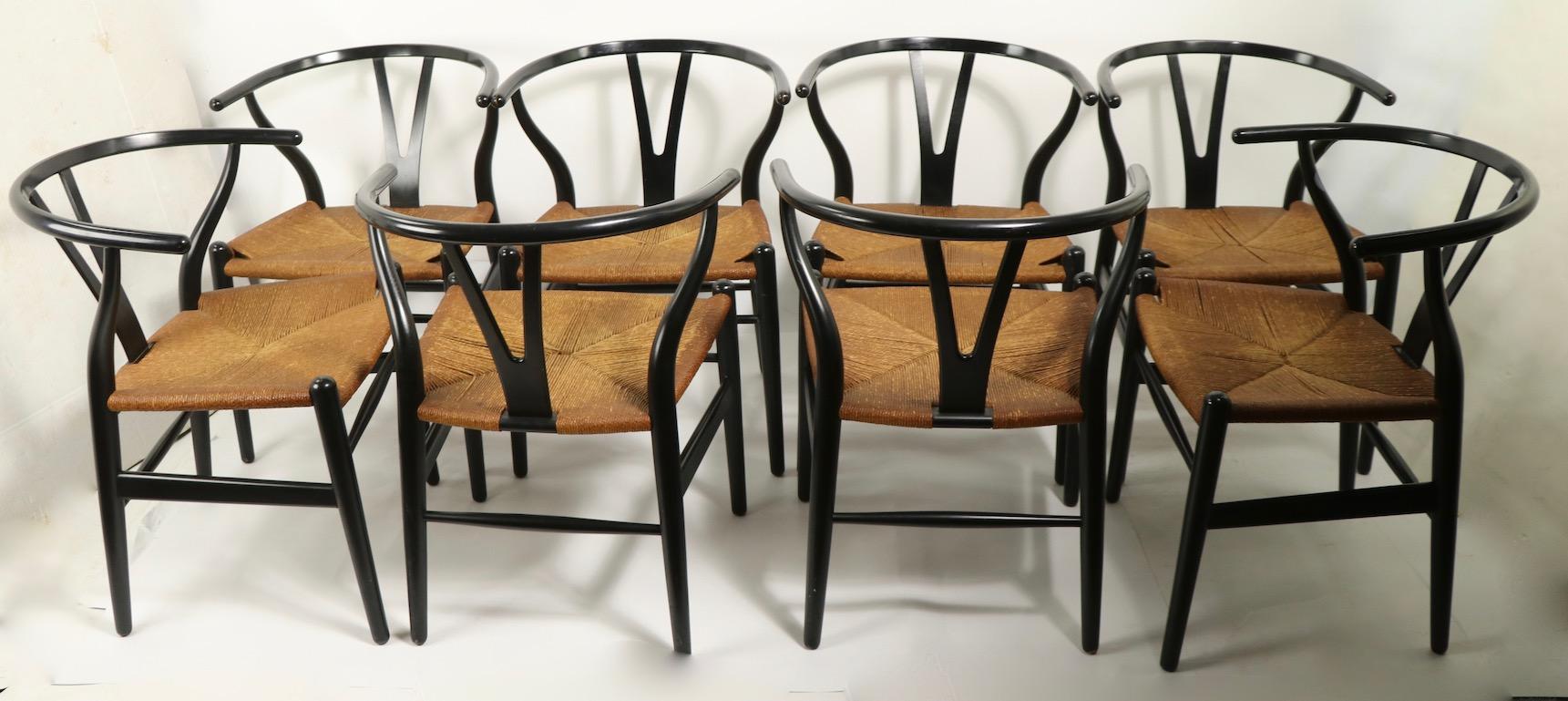 Wonderful set of 8 CH24 chairs designed by Hans Wegner executed by Carl Hansen. These chars are in original black finish with original paper cord seats. All are in very fine condition, showing only light cosmetic wear, normal and consistent with
