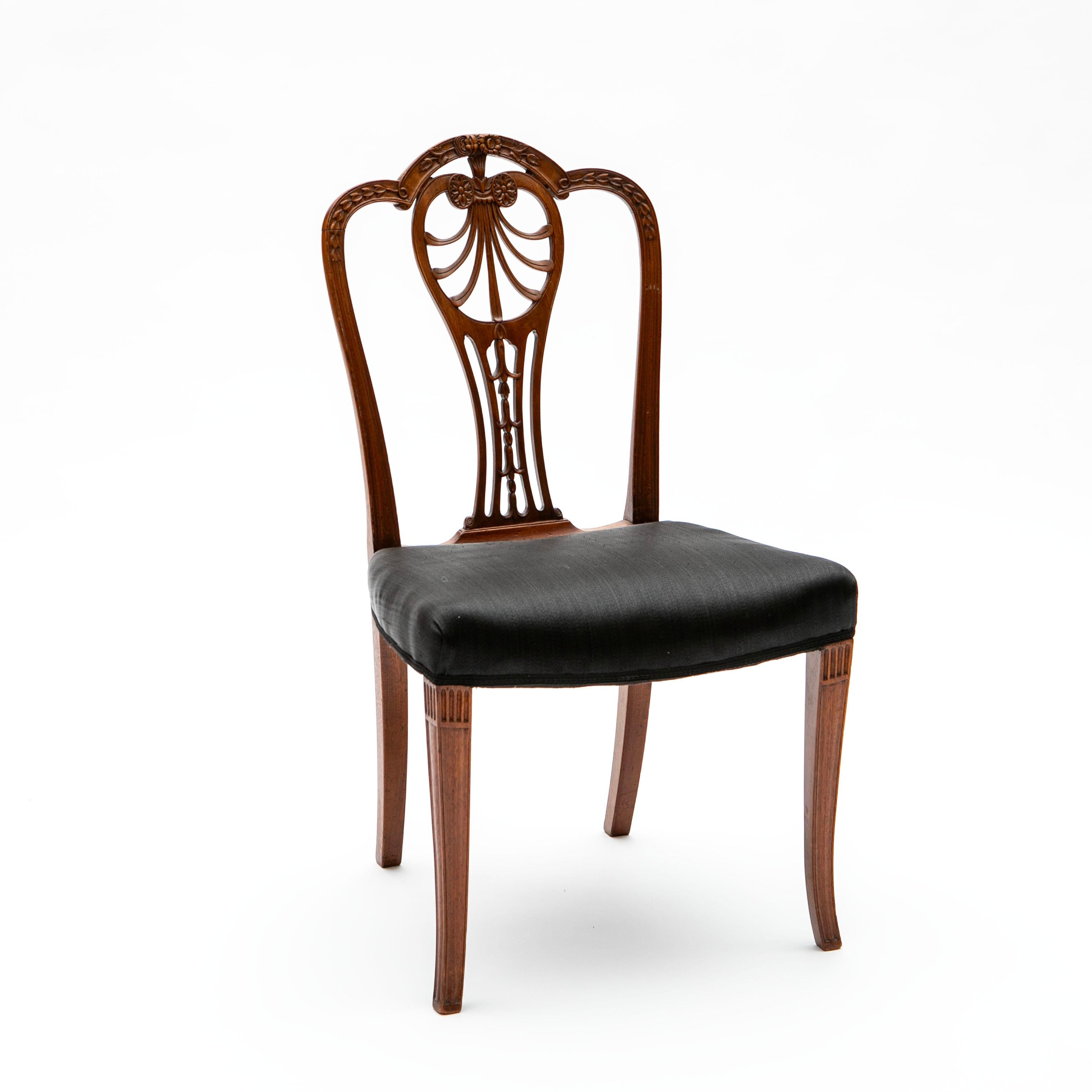 Elegant set of 8 chairs, including 2 armchairs and 6 side chairs.
Crafted in the Hepplewhite model, George III style, England, circa 1800.
Made of solid mahogany with a fan-shaped backrest featuring intricate carvings of floral and foliate