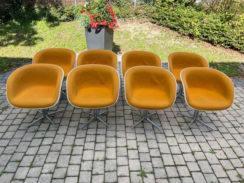 Ensemble de 8 fauteuils La Fonda, base chromée, fibre de verre blanche et tissu orange, conçus par Charles & Ray Eames dans les années 1960. 
Produit par Herman Miller, États-Unis. Toutes les chaises sont estampillées.
Bon état vintage.

