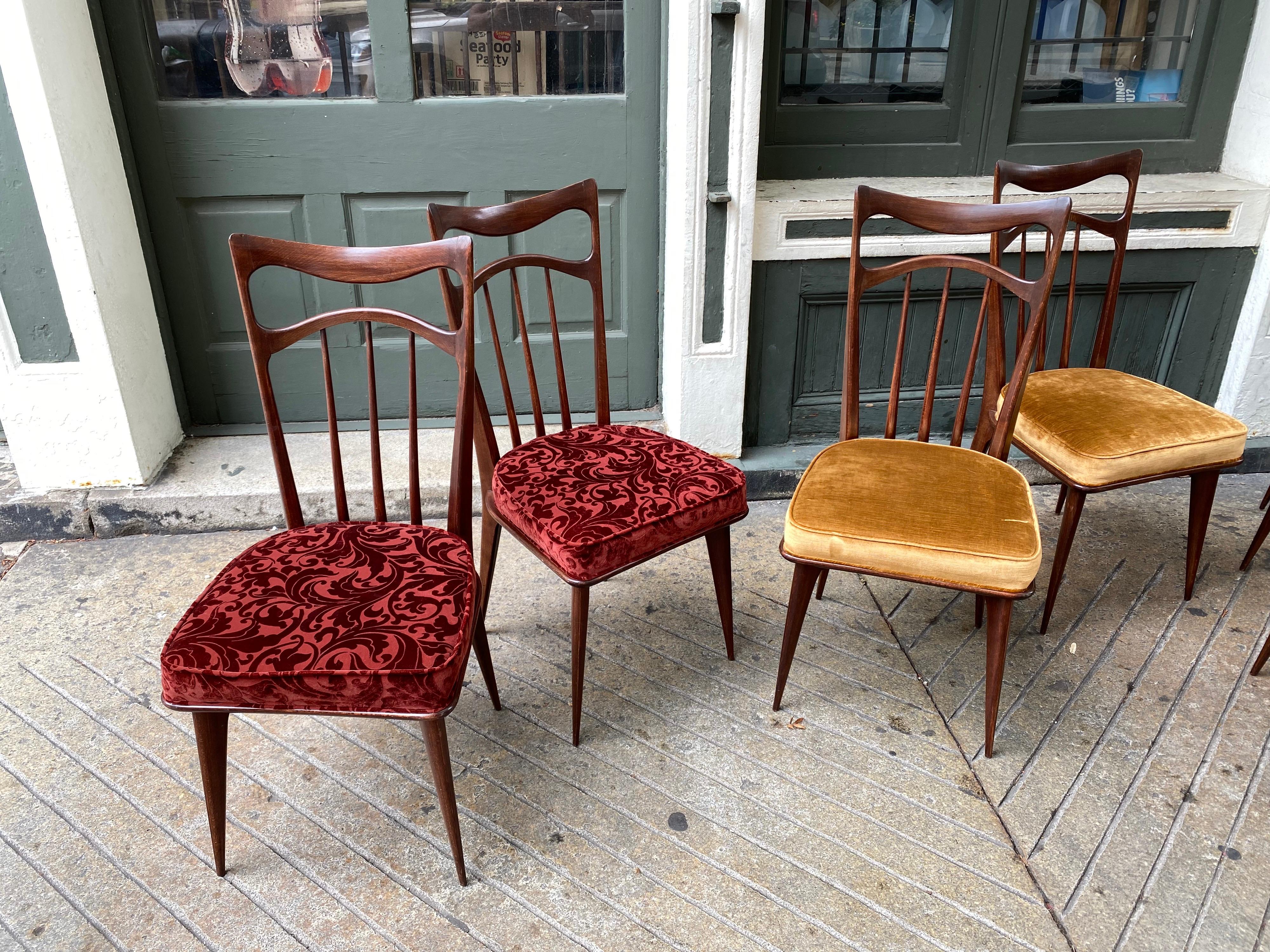 Set of 8 Italian dining chairs, darker walnut finish looks original. Backs have a Bowtie type design, nice thin legs gives the set a elegant look. 4 Chairs were reupholstered at some point where as 4 I believe are Original. Easy redo to make them