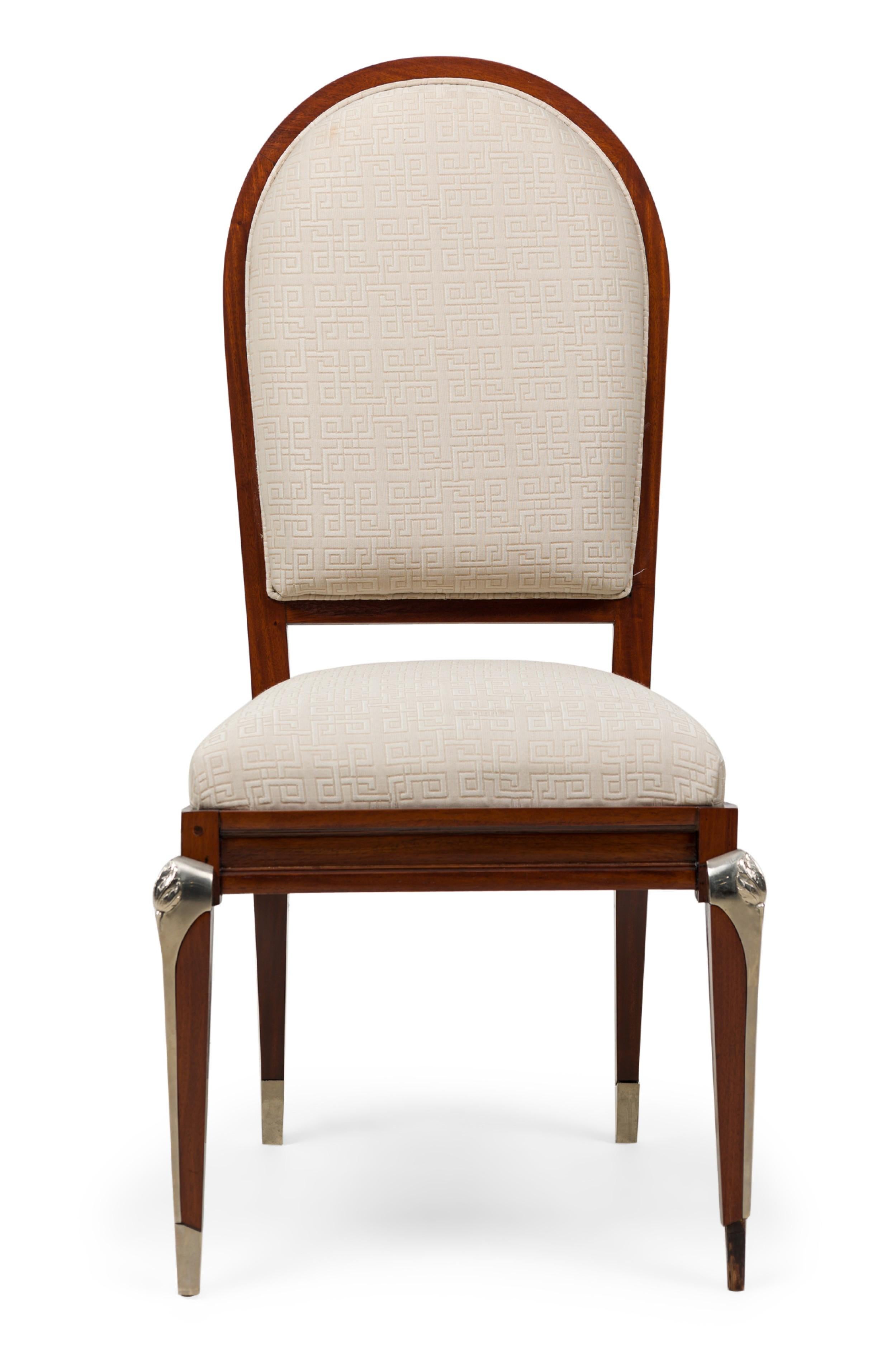 SET of 8 French Mid-Century mahogany dining chairs (2 armchairs, 6 side chairs) with rounded backs and tapered square legs with decorative silvered bronze mounts and sabots, upholstered in a lightly geometrically patterned off-white fabric. (JEAN