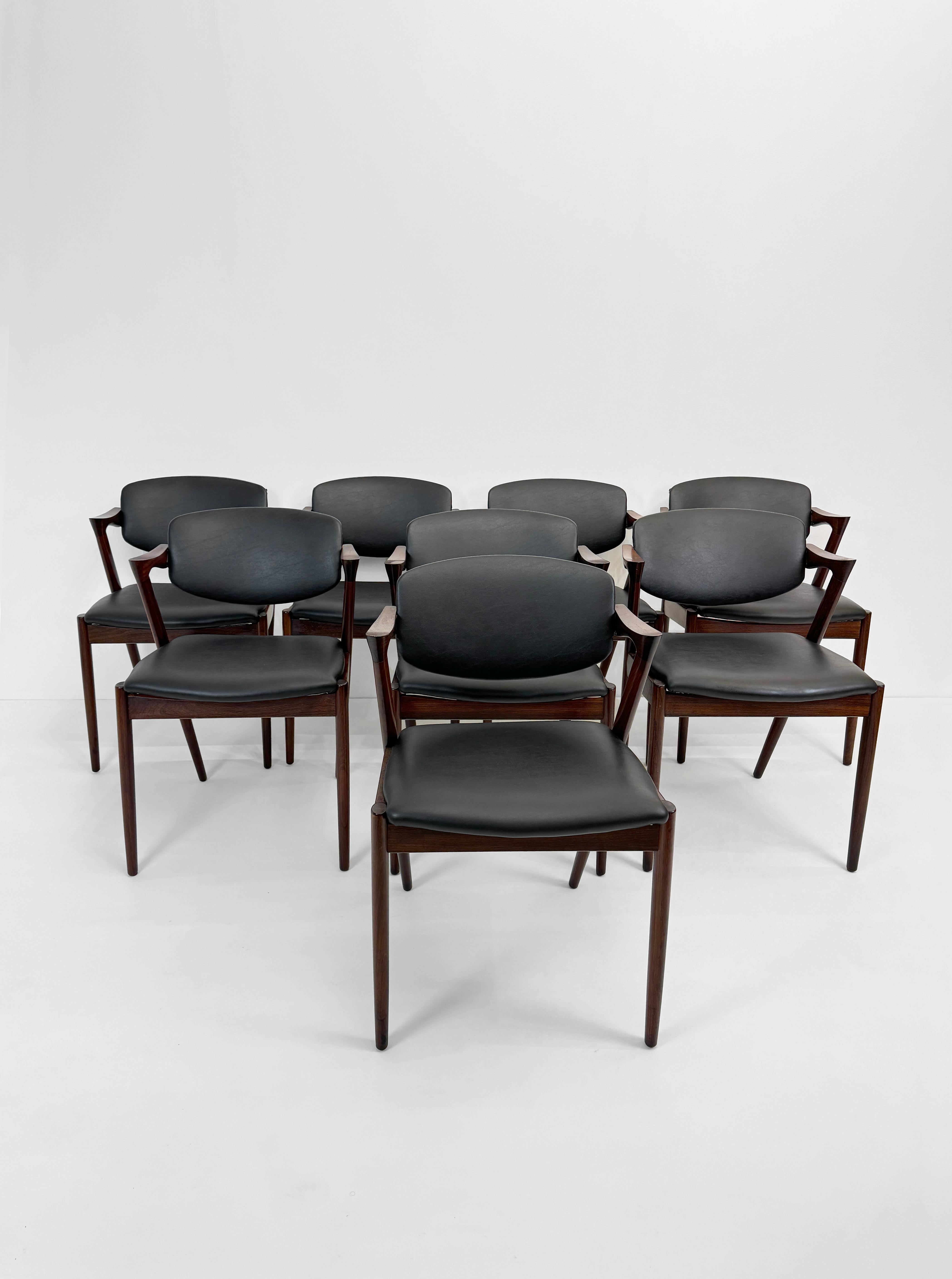 Set di 8 sedie da pranzo con struttura in palissandro e similpelle nera ad alta qualità con schienale girevole regolabile di Kai Kristiansen per Schous Møbelfabrik, presentato per la prima volta nel 1956. Le sedie hanno il tipico design leggero ed