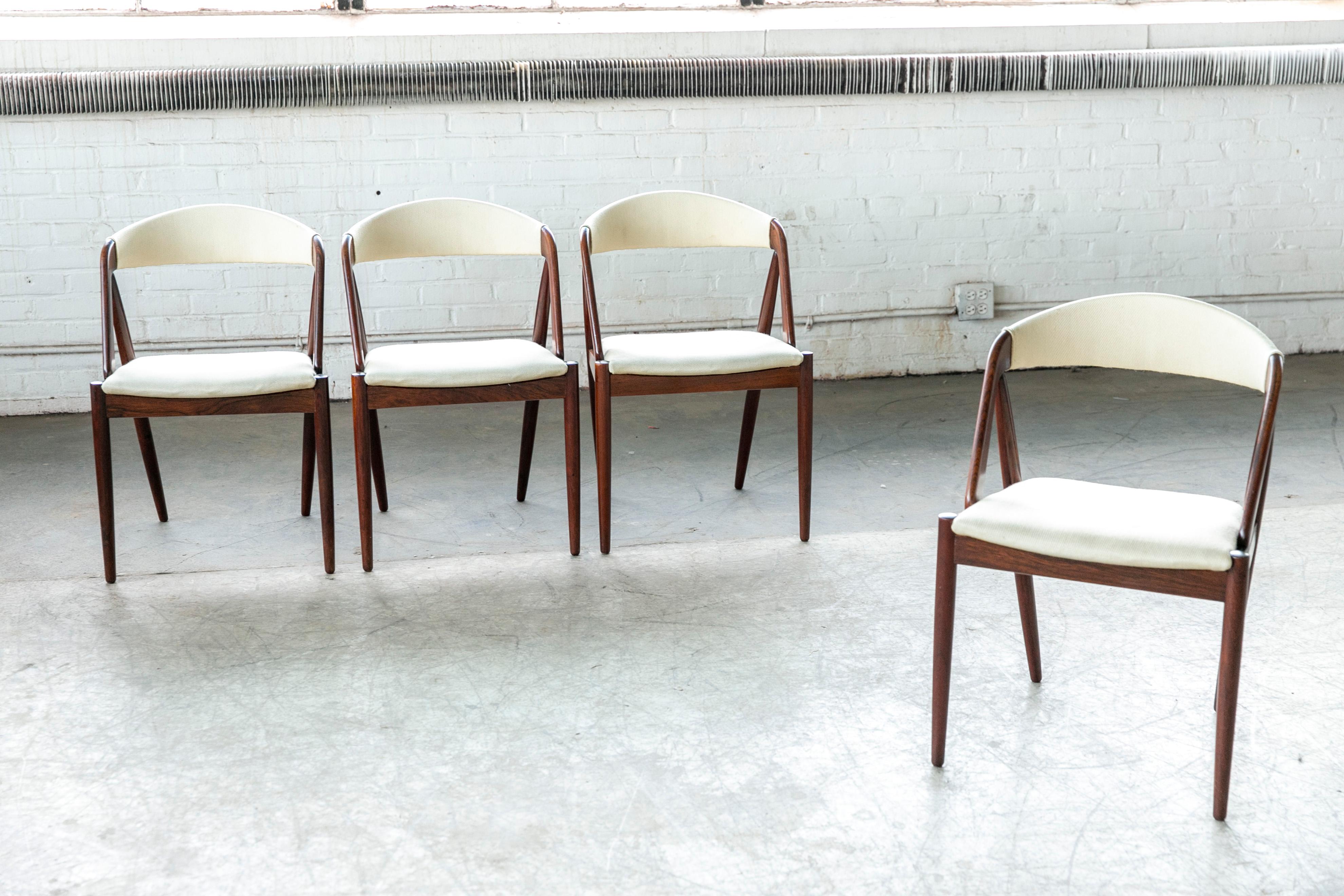 This set of four dining room chairs model 31 in rosewood designed by Kai Kristiansen in 1956 and manufactured by Schou Andersen in the 1960s in Denmark. The chairs are made from rosewood and upholstered in white fabric. Beautiful frames with very