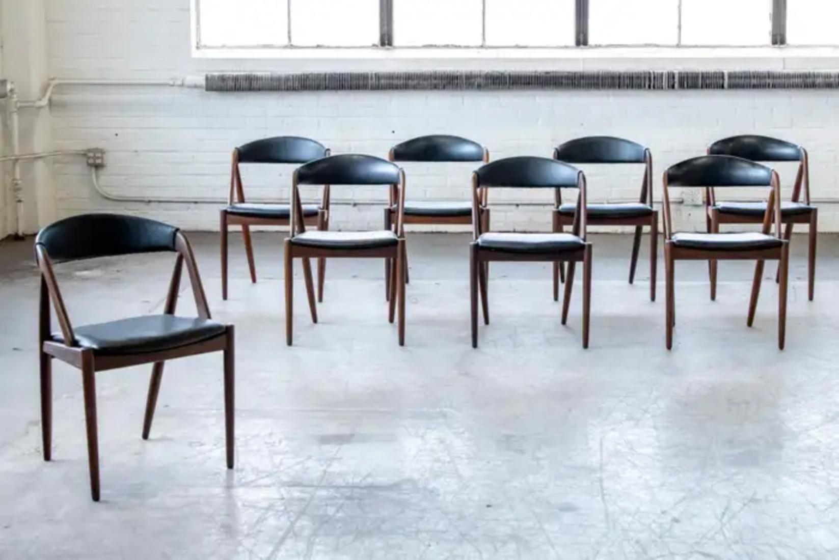 This set of eight dining room chairs was designed by Kai Kristiansen in 1956 and manufactured by Schou Andersen in the 1960s in Denmark. The chairs are made from teak and upholstered in black vinyl. Beautiful frames with very nice color and the