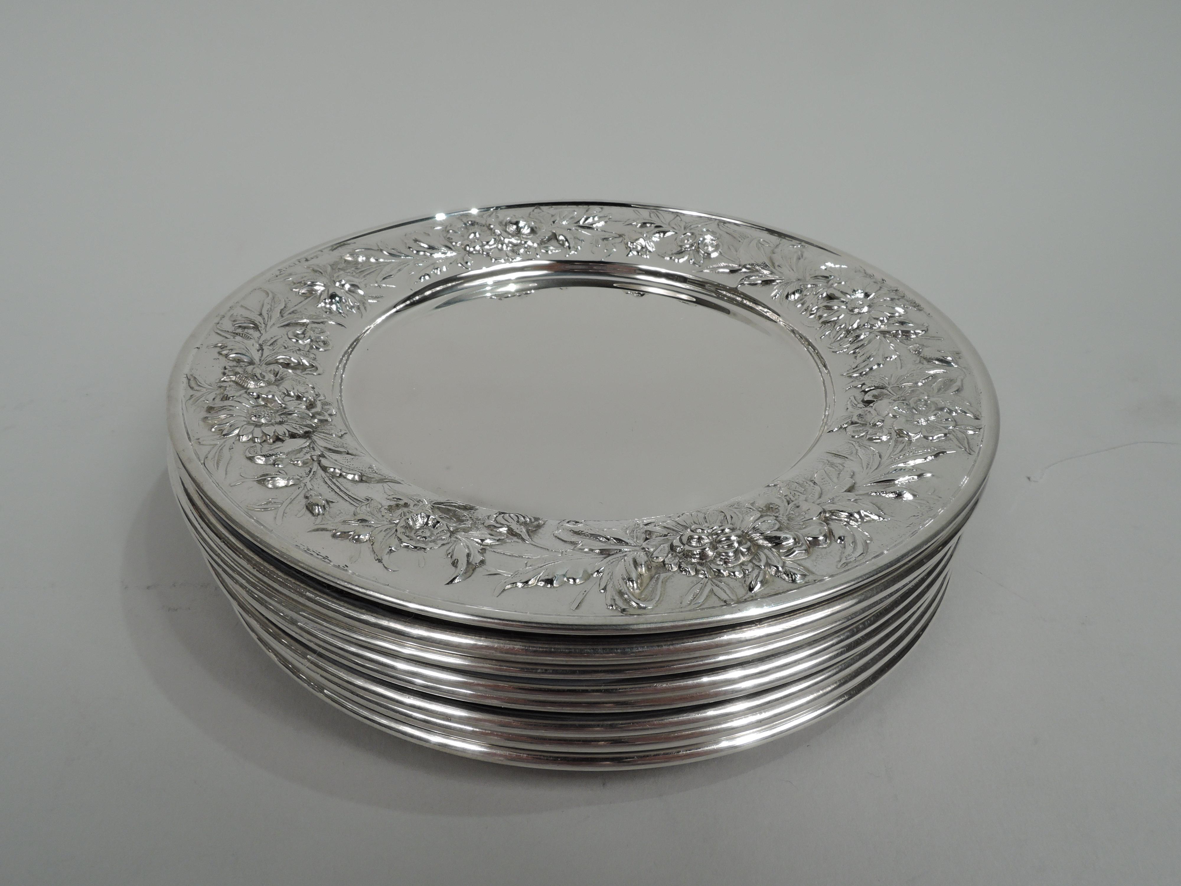 Set of 8 sterling silver bread and butter plates. Made by S. Kirk & Son in Baltimore, circa 1940. Each: Plain well; on shoulder repousse floral garland on stippled ground. Fully marked including maker’s stamp (1932-61) and no. 127F. Total weight:
