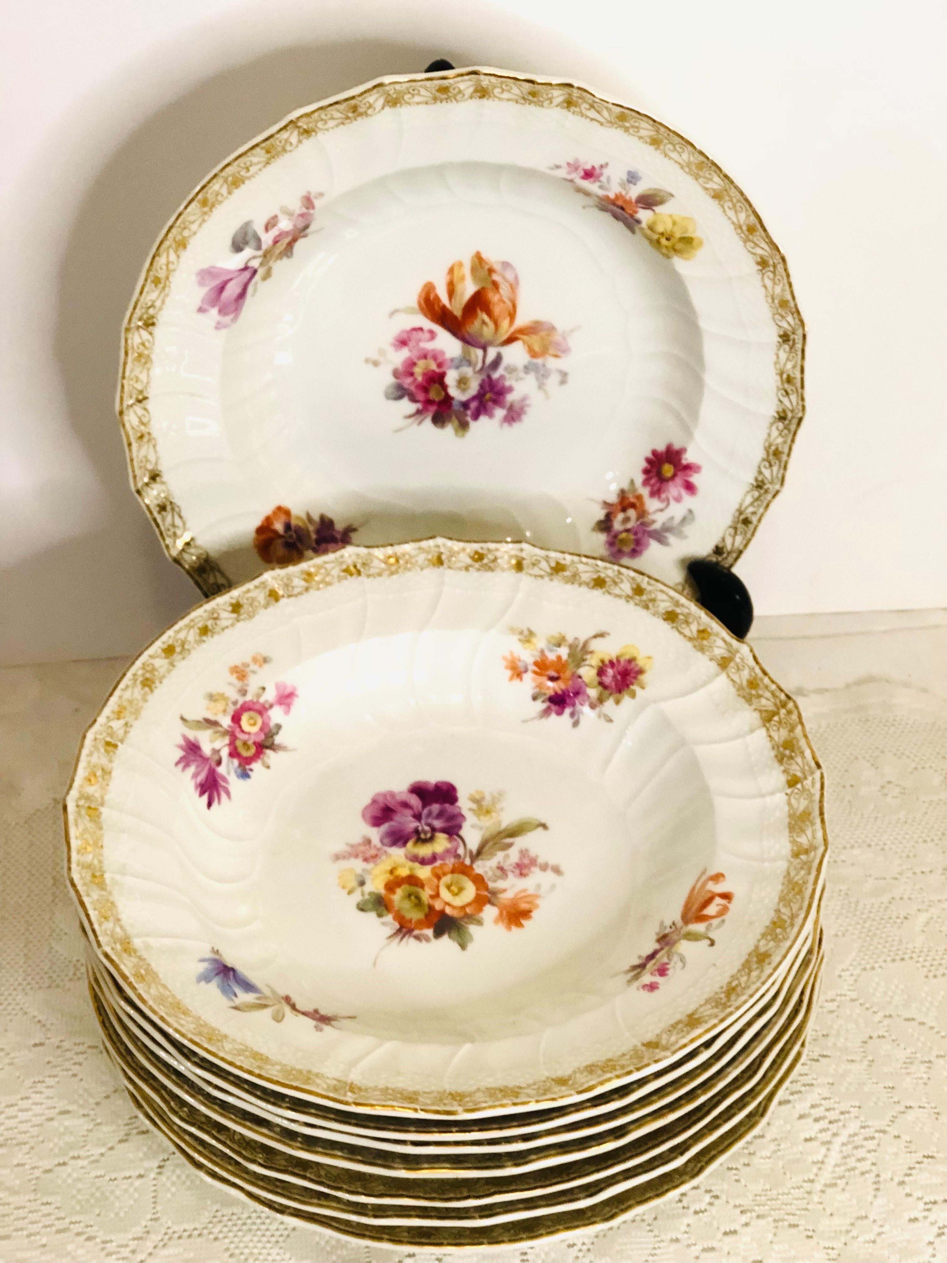 Set of eight beautiful KPM wide rim soup bowls with different central museum quality hand-painted floral bouquets on each bowl. KPM is also known as the Konigliche Porzellan-Manufaktur of Germany. They had very talented artists who did an