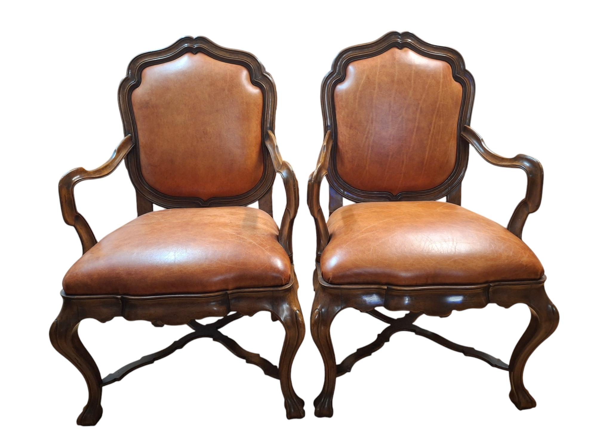 Magnifique ensemble de 8 grands fauteuils de style vénitien par Therien Workshop Studios. 
On ne saurait trop insister sur l'impressionnante qualité de l'exécution du noyer sculpté par des experts.  Chaque chaise est recouverte d'un riche cuir fin