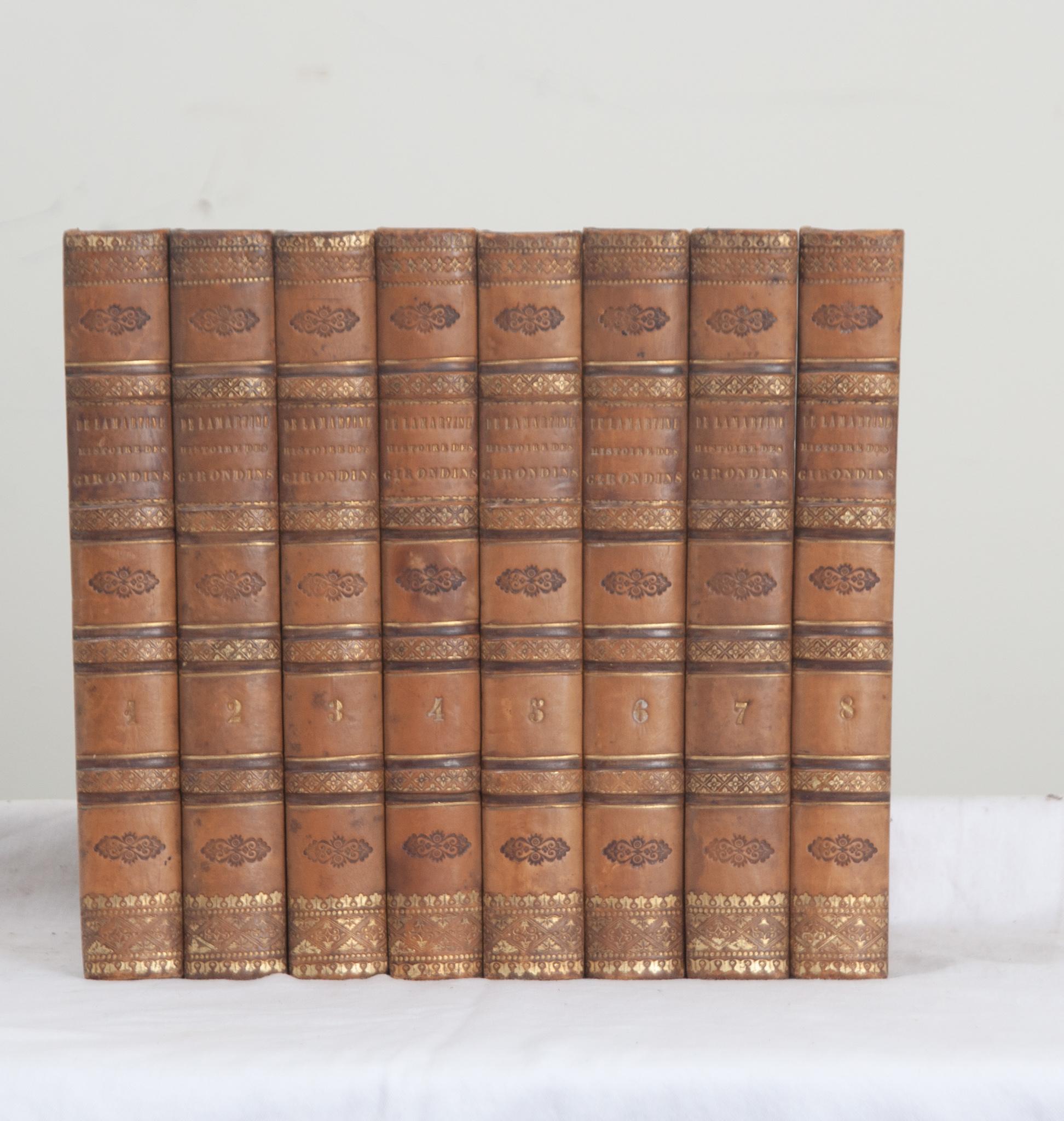 A collection of eight leather bound volumes on the Girondins by French author Alphonse de Lamartine. This set of books have marbled paper front and back covers stamped with gold tooling with the author, title, and respective volume. Written in 1847,