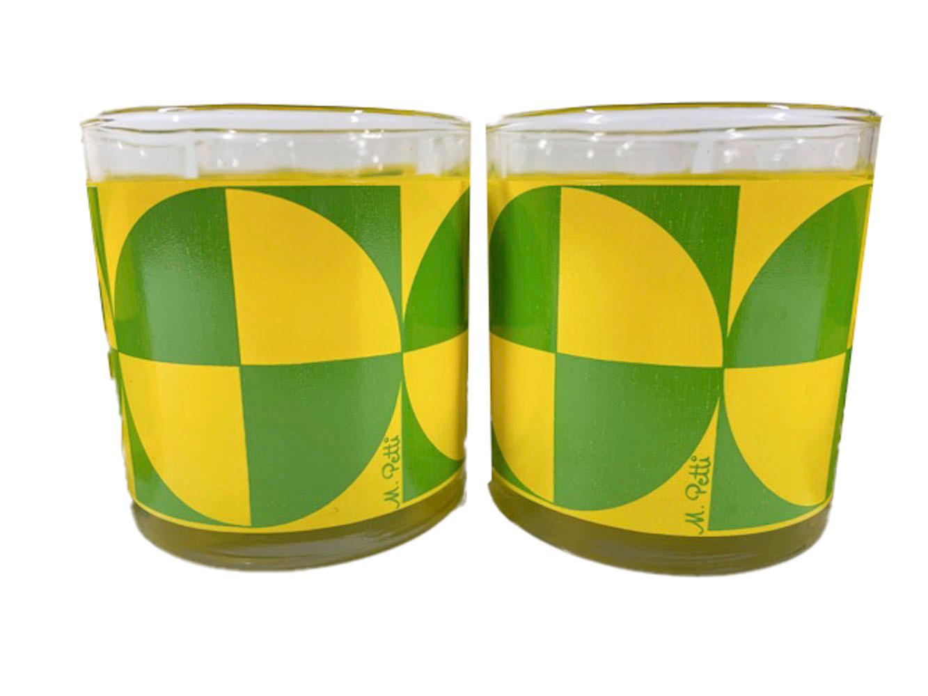 Eight mid-century modern rocks glasses by Libbey with a green and yellow Op-Art design by M. Petti. Large quartered circles with alternating green and yellow fields touch and combine with the contrasting negative space creating opposing squares.