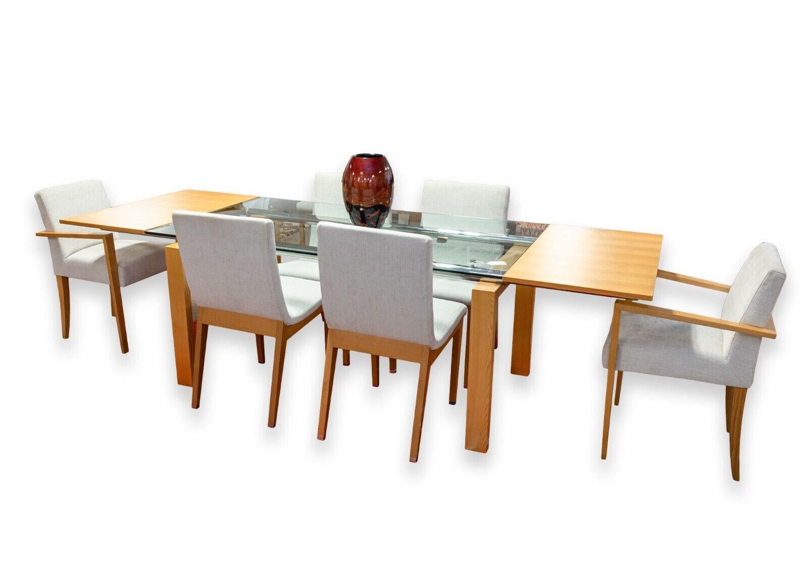 A set of 8 Ligne Roset dining chairs. A beautiful, modern set of dining chairs dawning a sleek grey upholstery and constructed with a light beech wood frame. This set includes 2 arm chairs and 6 side chairs. The arm chairs feature a wonderful
