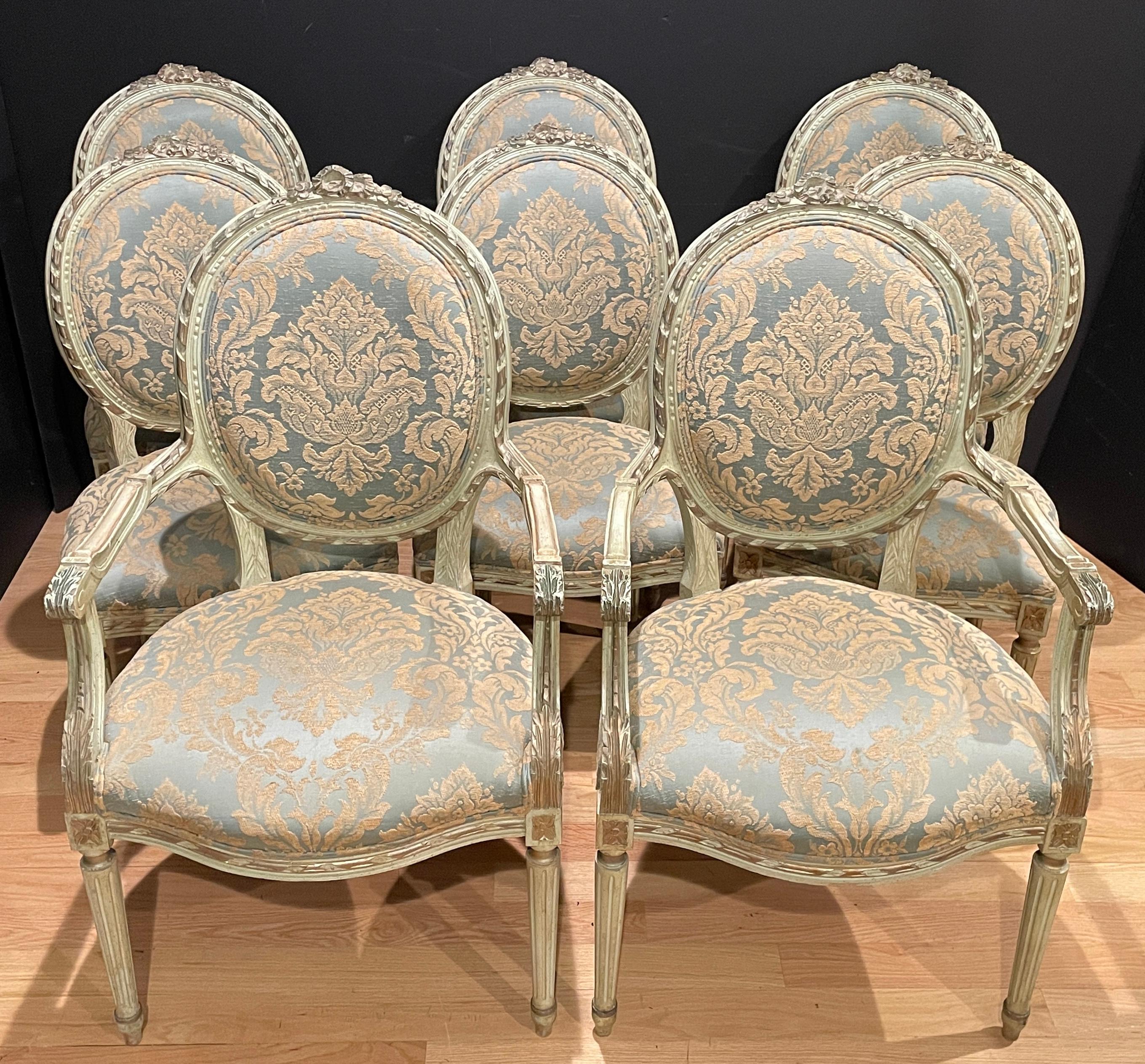 Set of eight Louis XVI style 19th century hand carved, painted and gilt dining chairs. Carved ribbon and rosettes.
Measures: Armchairs: 24