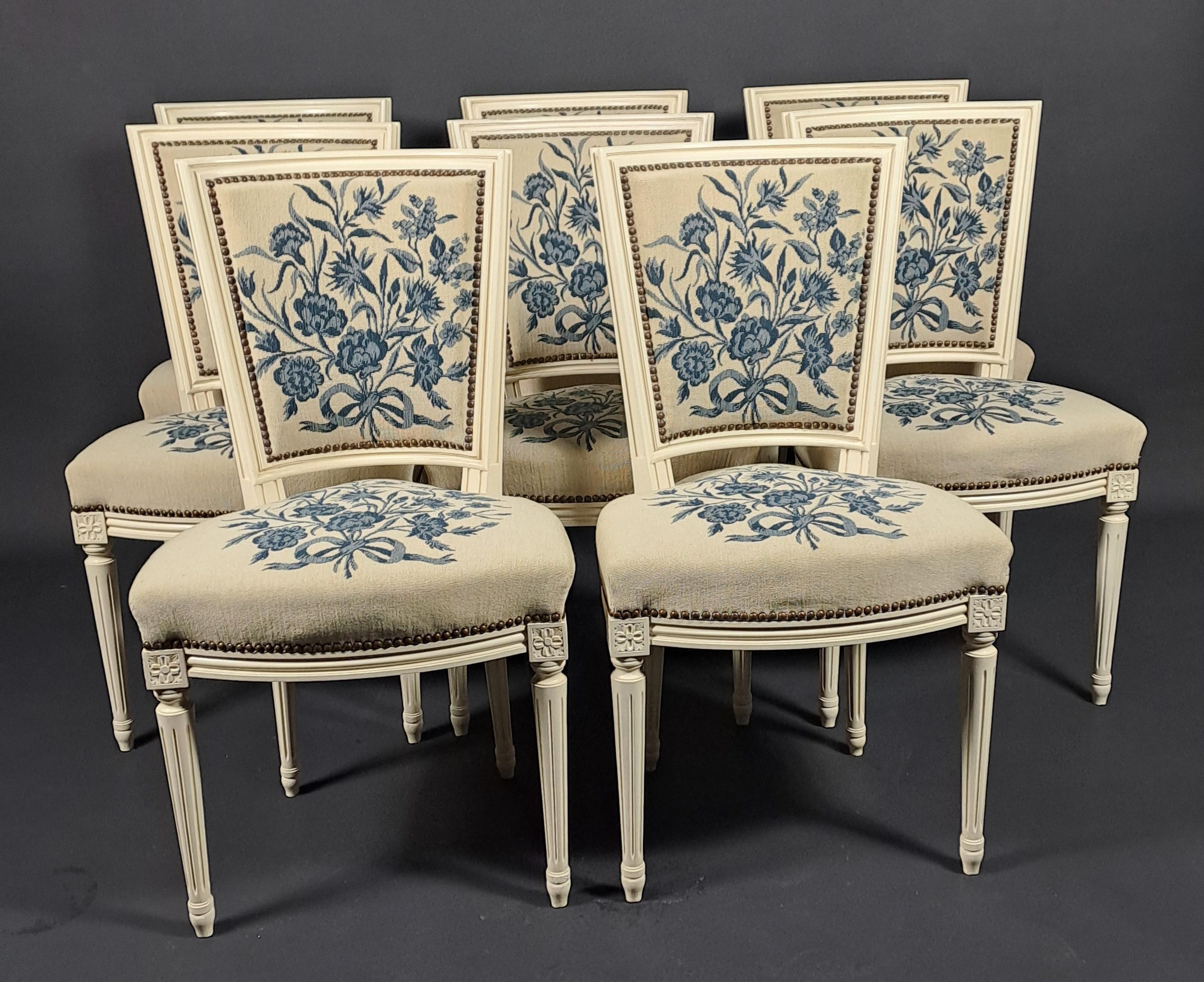 Set of 8 Louis XVI style dining room chairs in white lacquered carved wood, upholstered with a cross-stitch tapestry with blue floral decoration on a beige background.

Work of good quality from the 50s
Solid beech

Very good condition - upholstery