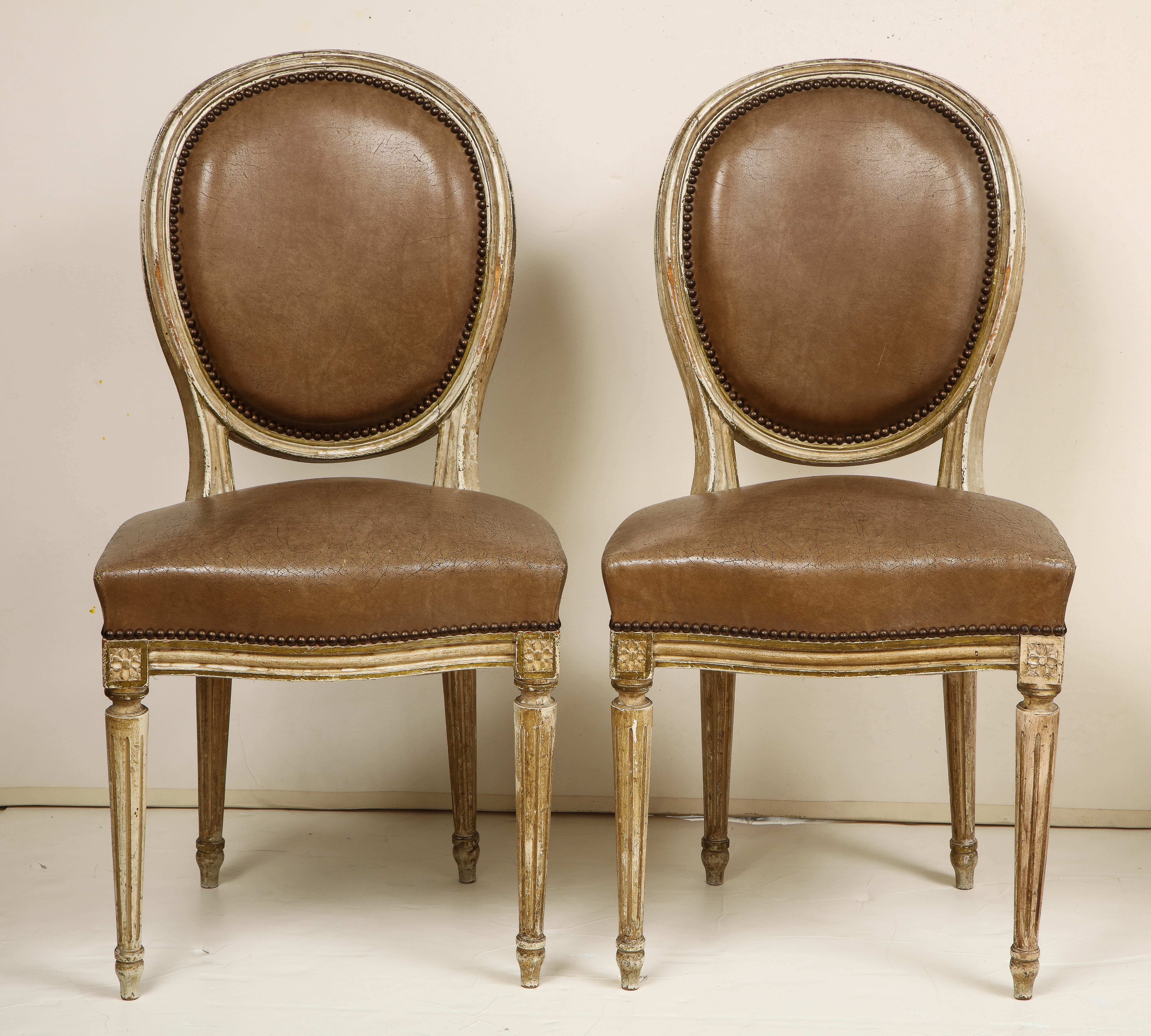 We love the Louis XVI style for its timeless, understated elegance. These eight dining chairs are painted in a soft, creamy white and are upholstered in a rich, brown leather that has aged to perfection! The chairs feature oval backs and details