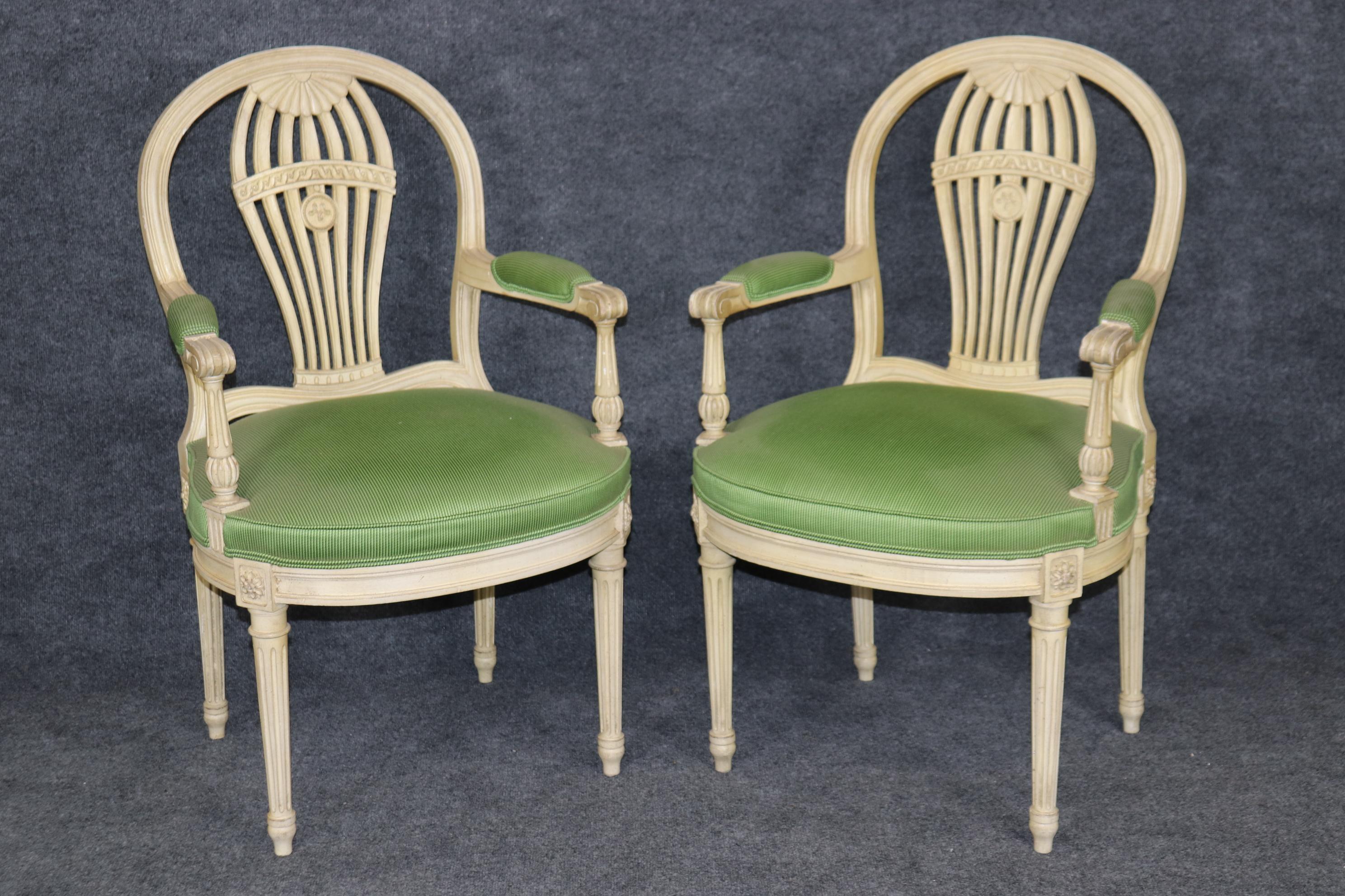 This is a gorgeous set of 8 French-made Maison Jansen dining chairs in the balloon back style. The chairs show a time-worn painted off-white finish and some tell-tale signs of age such as distressing and finish variations from fading. The upholstery
