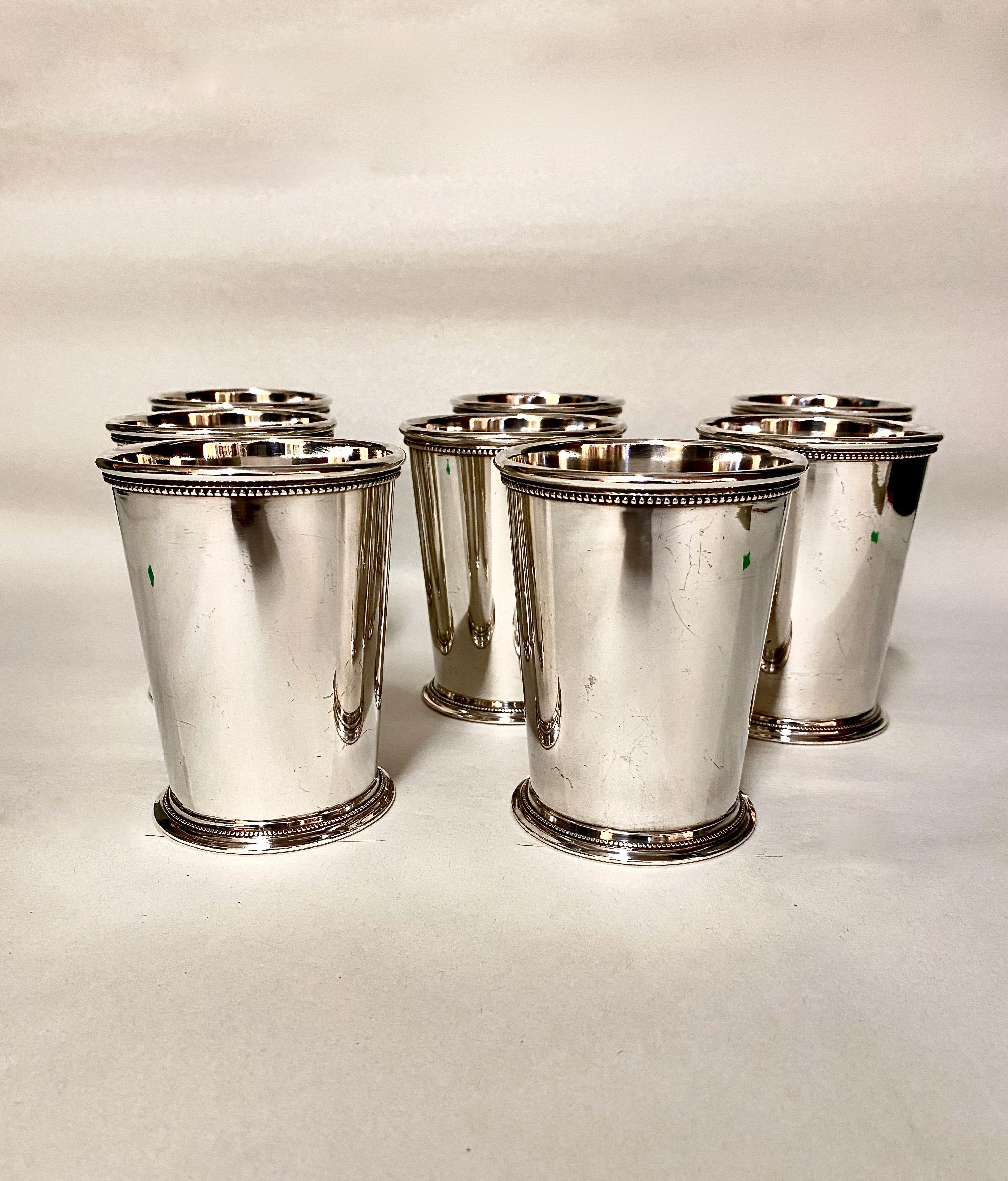 This is a wonderful set of 8 English-made mid-20th century mint julep cups. The heavy silver plate is in overall very good condition with hints of use. The rims and feet of the cups are detailed in beading and banding--both marks of quality. The
