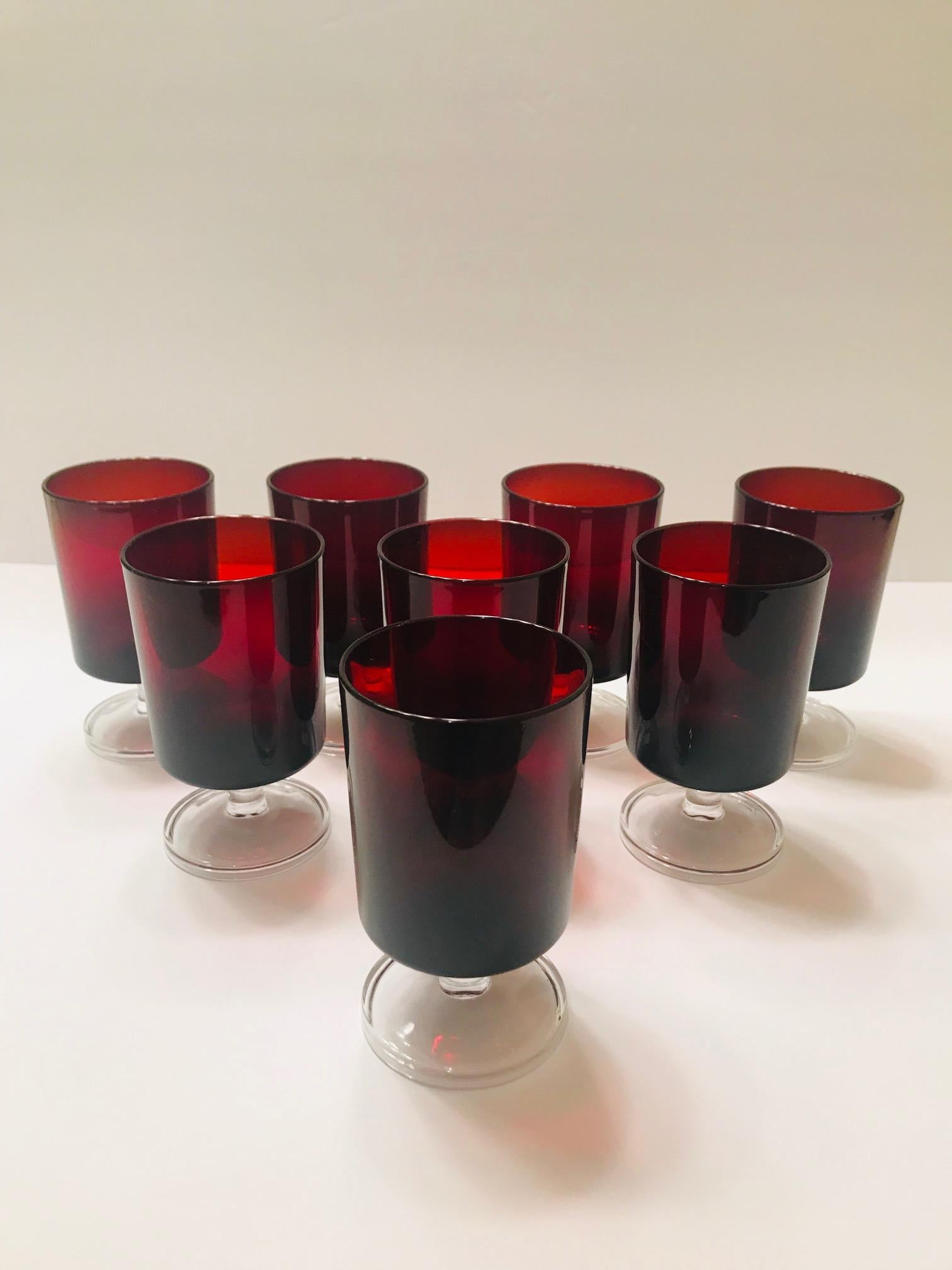 Set of eight French vintage crystal wine or liquor glasses in jewel tone red with clear glass stems. Glasses have Minimalist design with cylinder forms. Stamped 