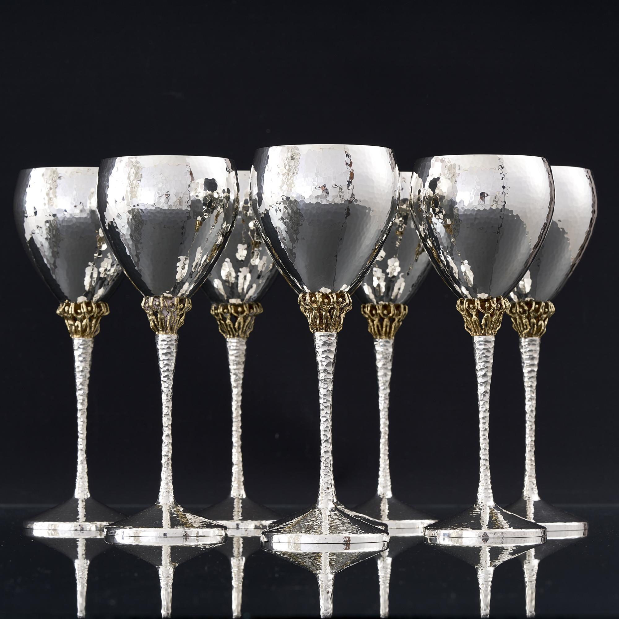 A set of eight mid-century silver wine goblets by one of the finest silversmiths of the 20th century, Stuart Devlin, and reflecting his very distinctive decorative style. The hand raised bowls and cast tapering stems are hand hammered and