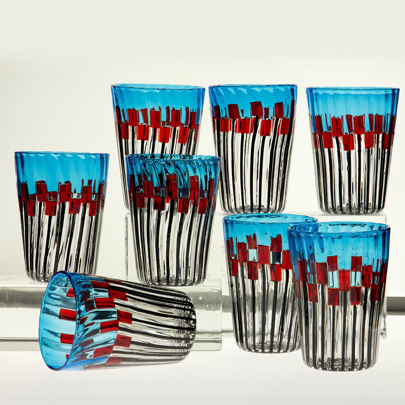 Un juego de ocho vasos de cristal de Murano con una intrincada decoración que combina filigrana negra con detalles en rojo intenso y un toque de aguamarina. El diseño fusiona influencias de diseñadores de renombre, creando un efecto de mosaico con